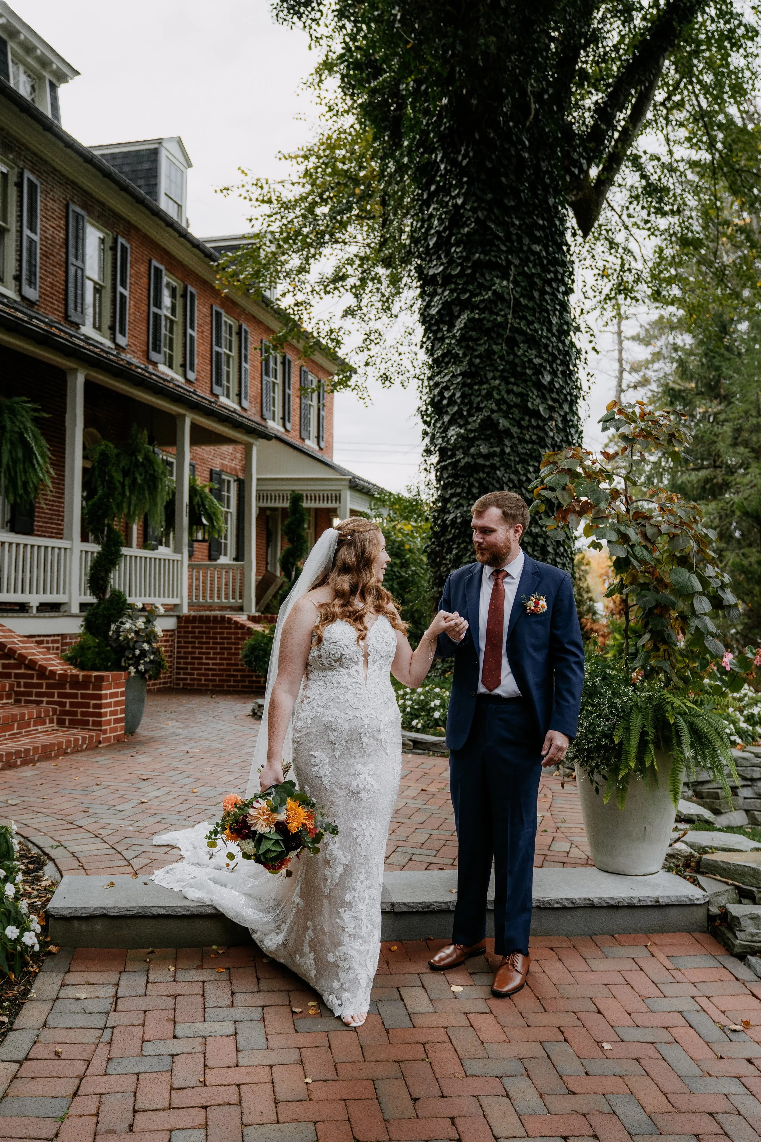 Bride and groom walking on brick path outside Stone Mill Inn in Hallam, PA