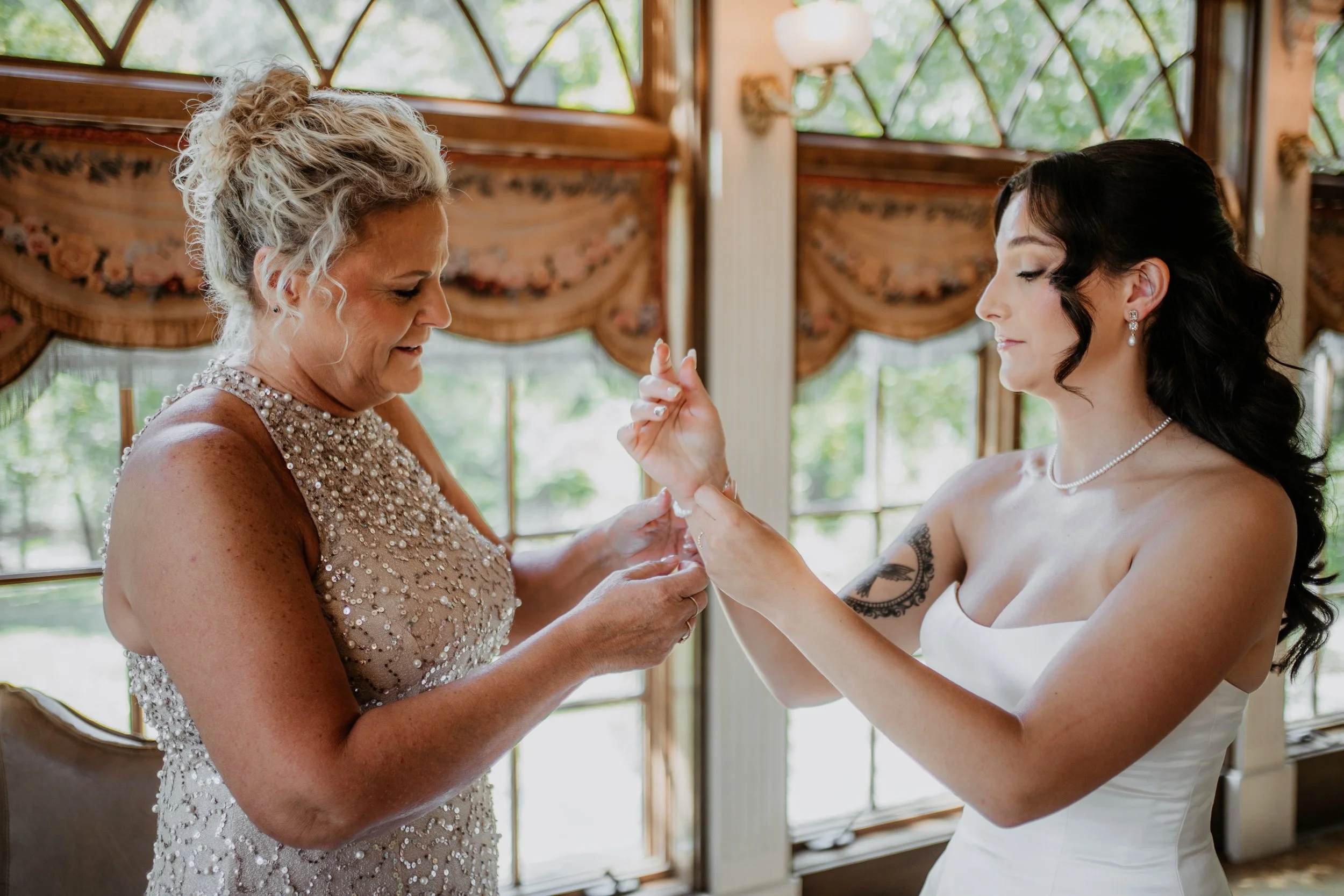 mother helps her daughter put on a bracelet for her wedding day at moonstone manor in elizabethtown pa