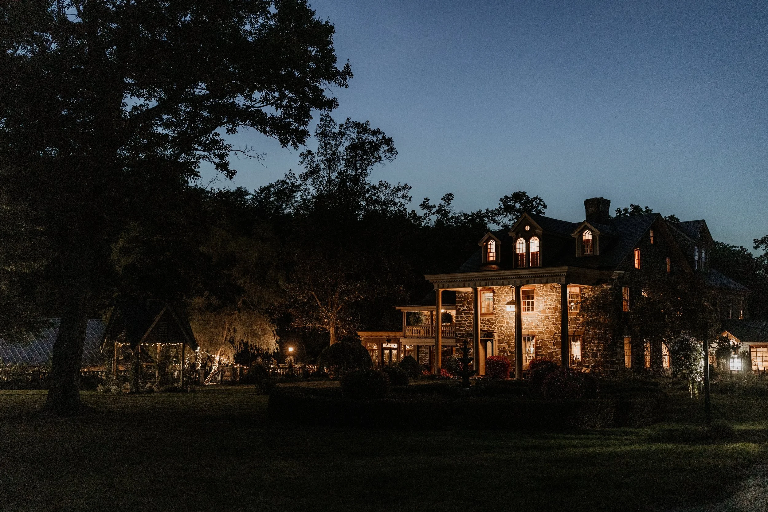 nighttime view of the moonstone manor with lights illuminating the mansion