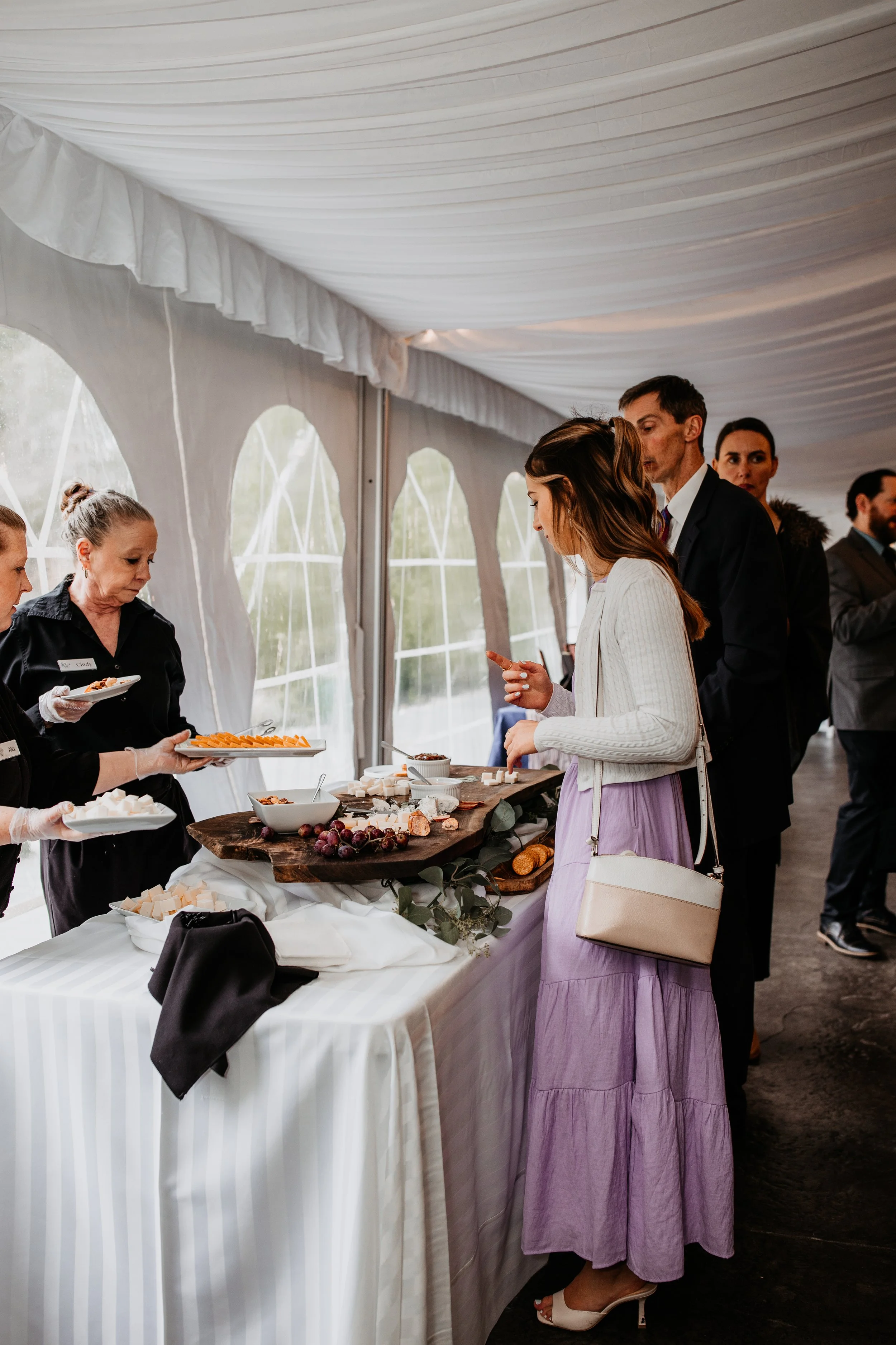 guests looking at grazing table during cocktail hour under a tent at the Stone Mill Inn