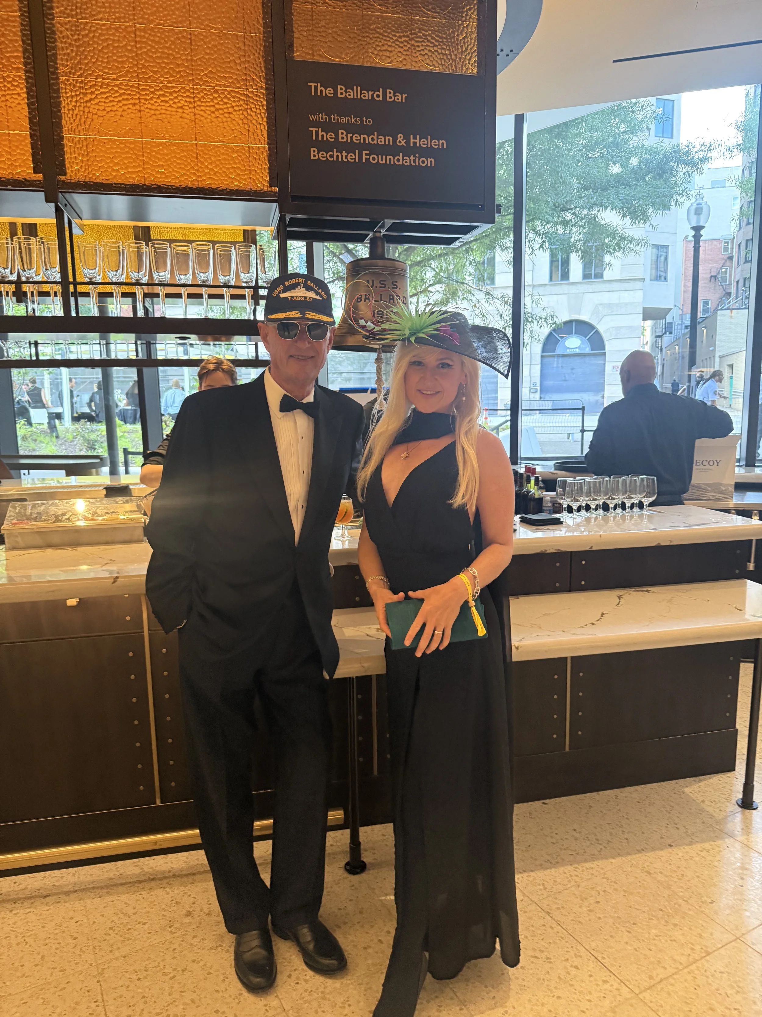 Anne A. Madden, (wearing a Microbe Hat featuring a 3D print of the PCR-enabling enzyme that came from an extremophile microbe) (right), next to National Geographic Explorer Bob Ballard (left), who discovered hydrothermal vent communities and the Tita