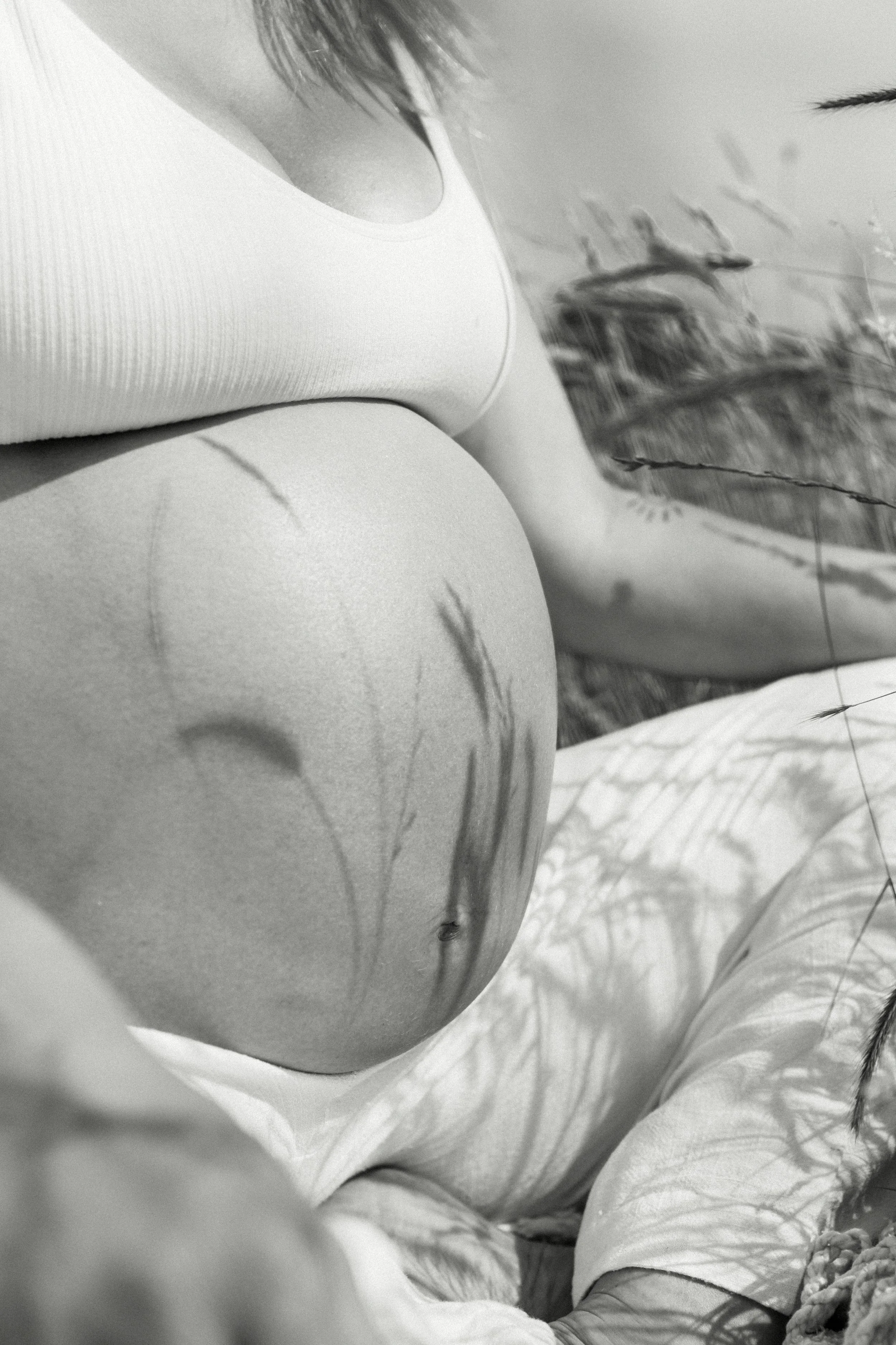 pregnant belly grass shadows outside summer black white monotone contrast