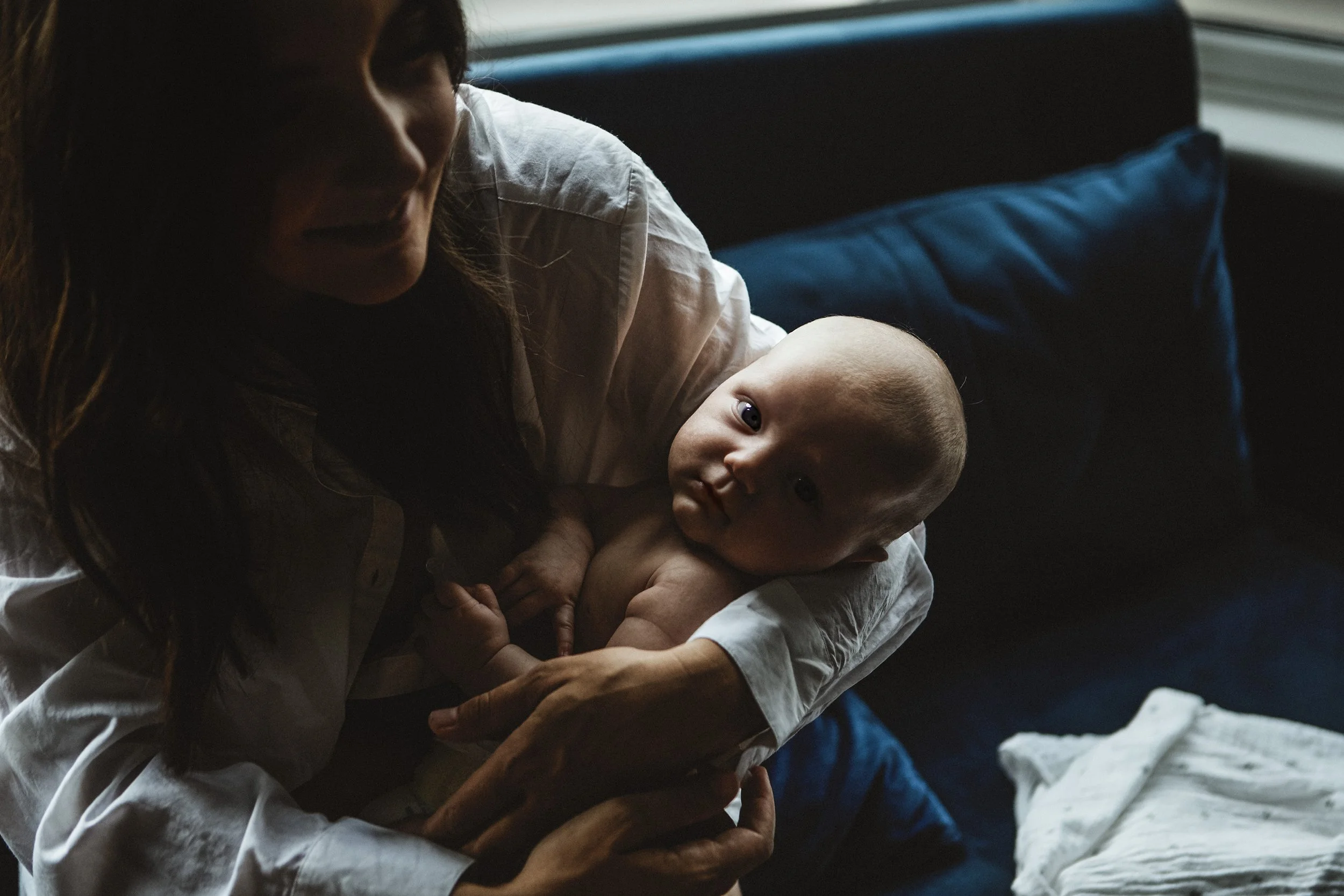 Mother baby natural light blue velvet sofa natural pose baby looking camera