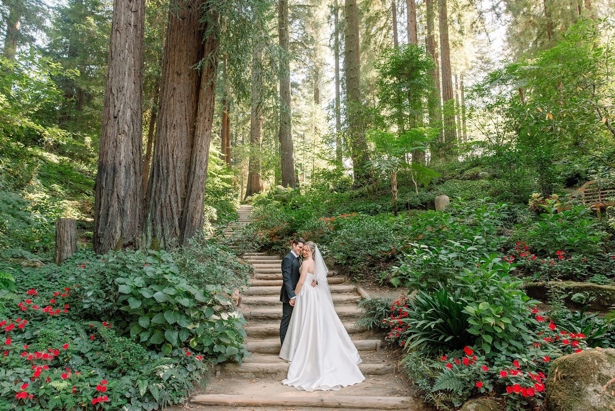 Alexandra and Chandler embrace in the redwoods at Nestldown, smiling and soaking in a quiet moment together after their ceremony
