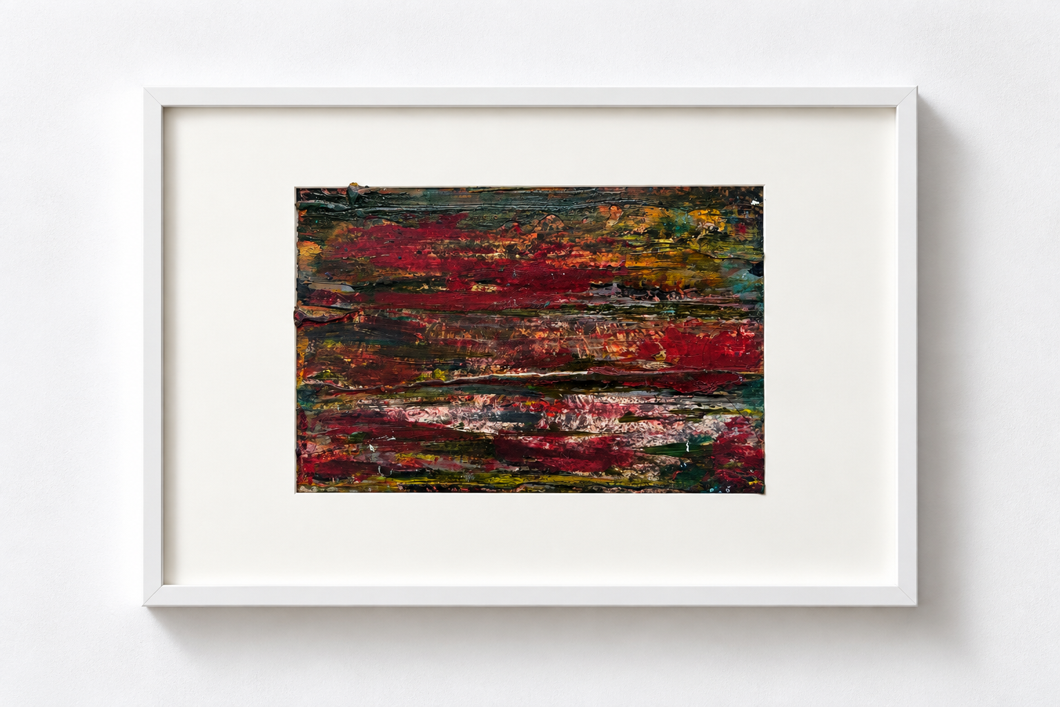 Abstract painting with bold, textured brushstrokes in red, green, pink, and yellow hues framed in white, hung on a white wall.