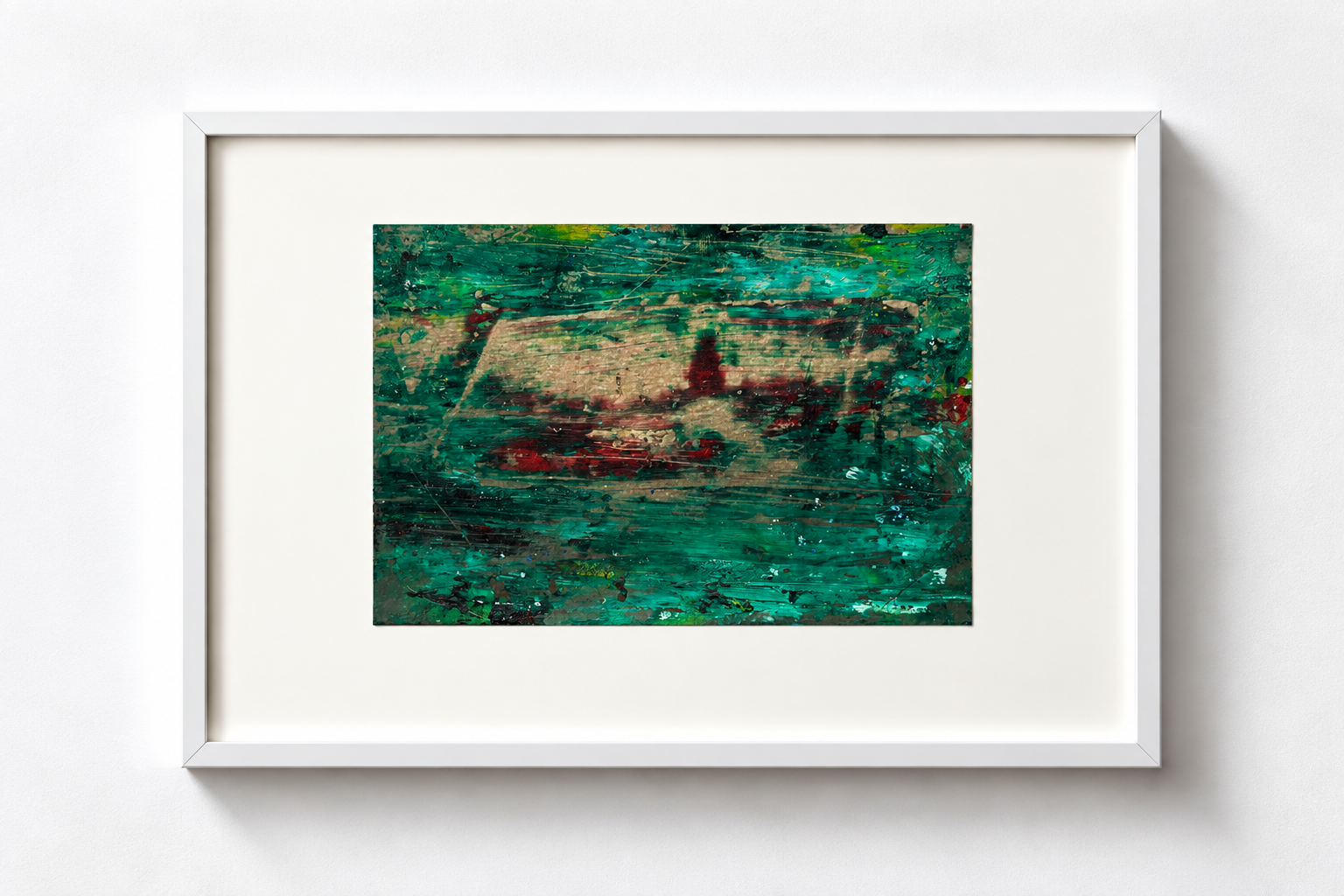 Abstract painting with green, red, and black colors in a white frame hanging on a white wall.