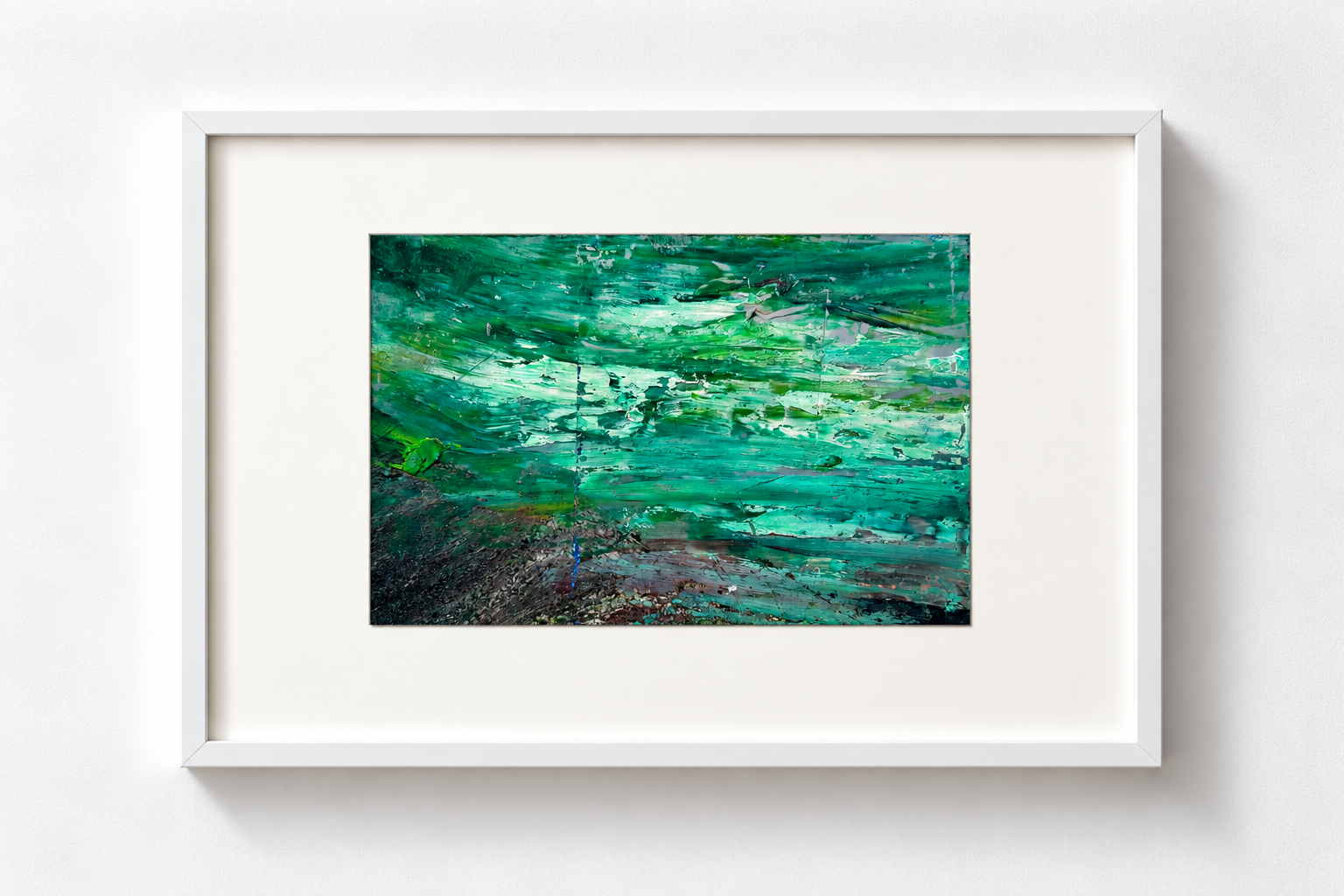 Abstract green and blue painting in a white frame on a white wall.