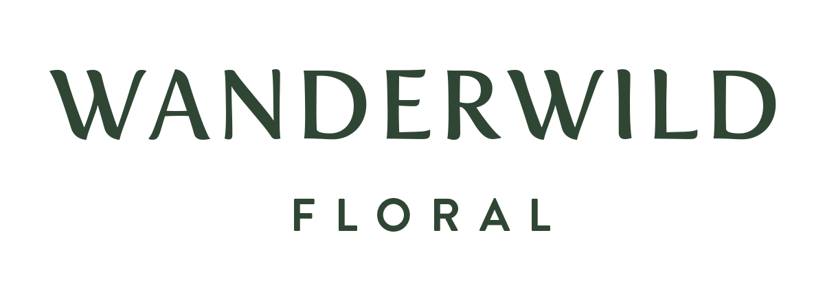 Wanderwild Floral logo in black text with a floral graphic above the text