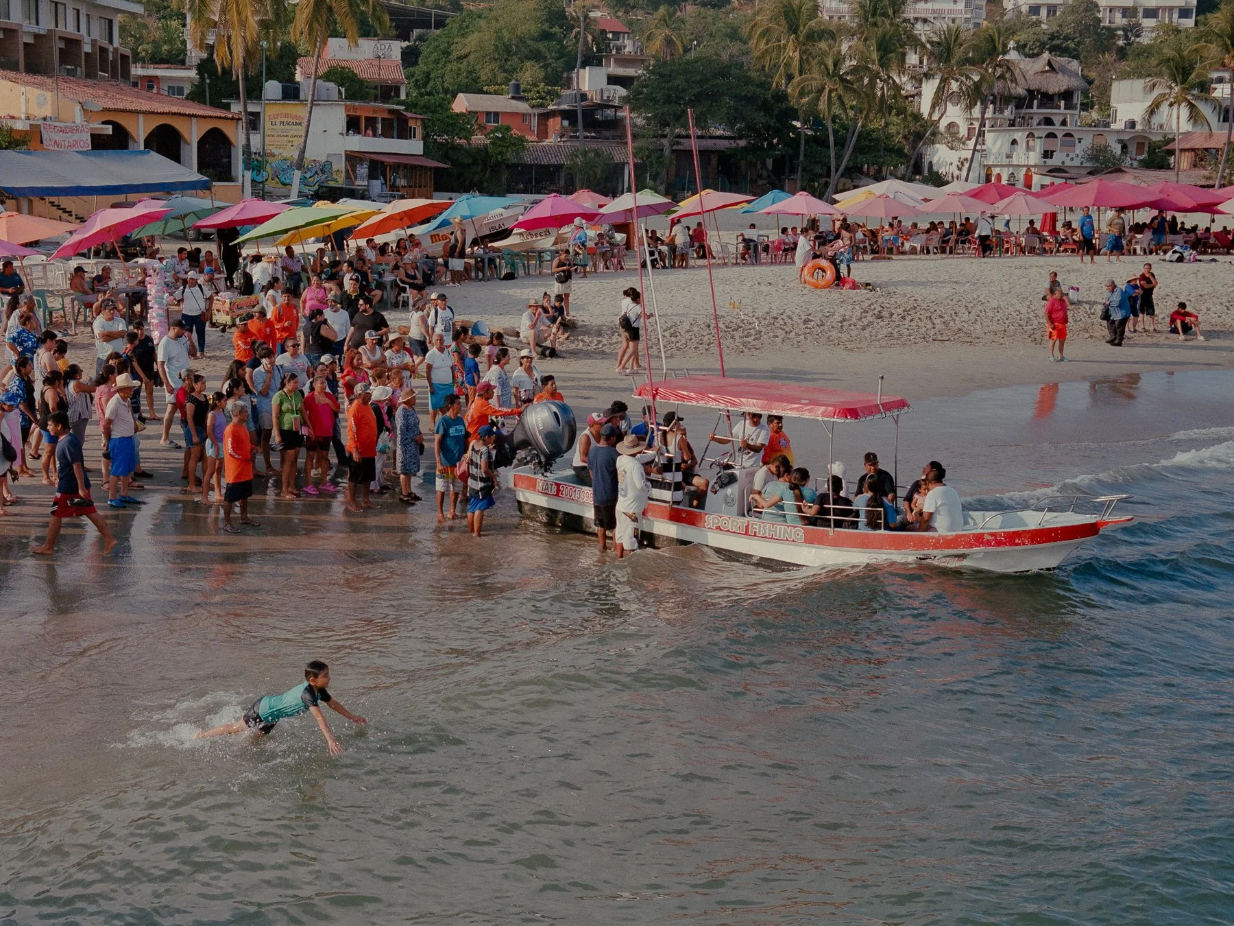 People waiting to be taken out to sea to follow the Virgin of Solitude