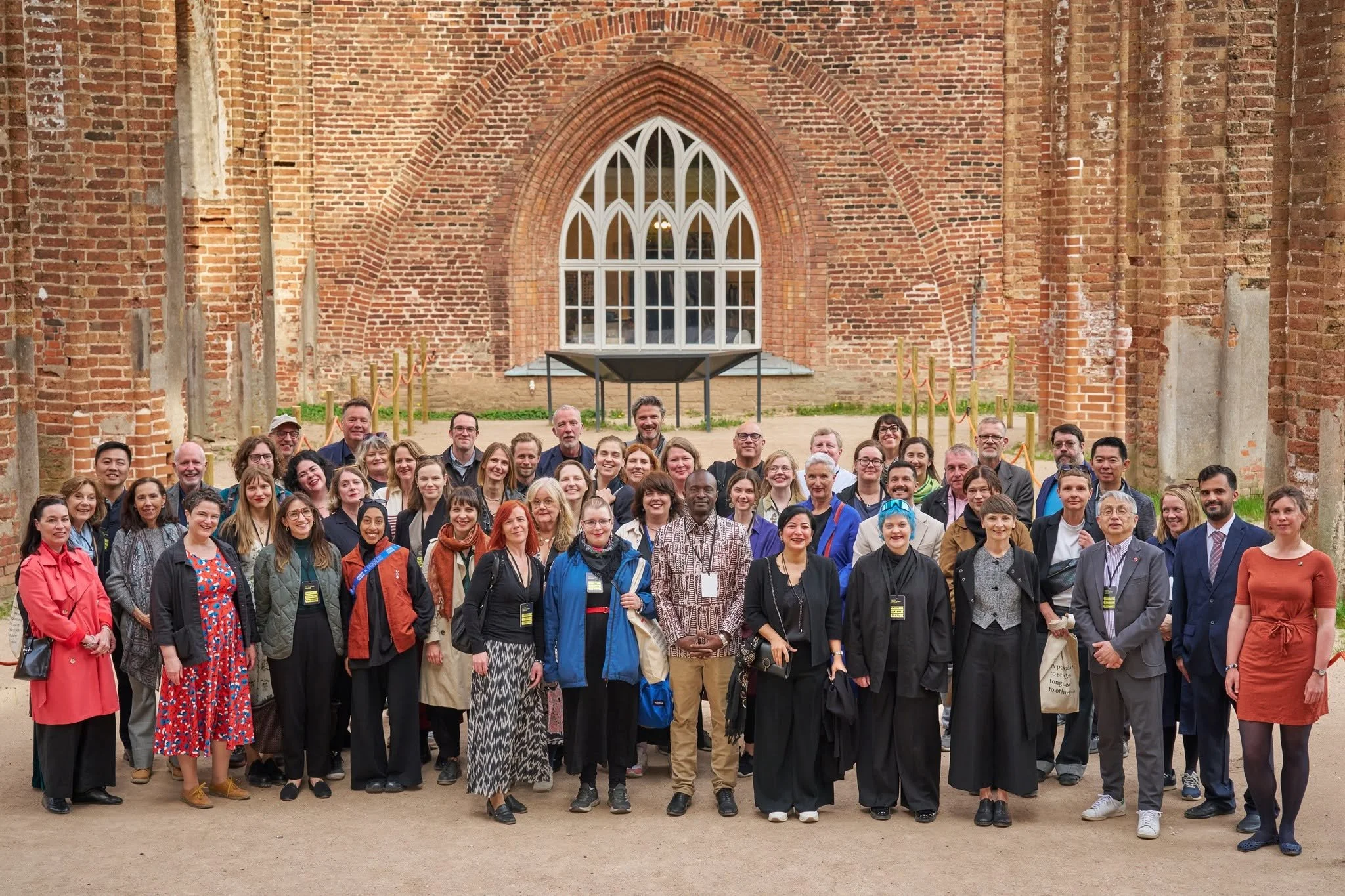 Representatives from UNESCO Cities of Literature across the globe pose for a photo in front of an old stone building in Tartu, Estonia.