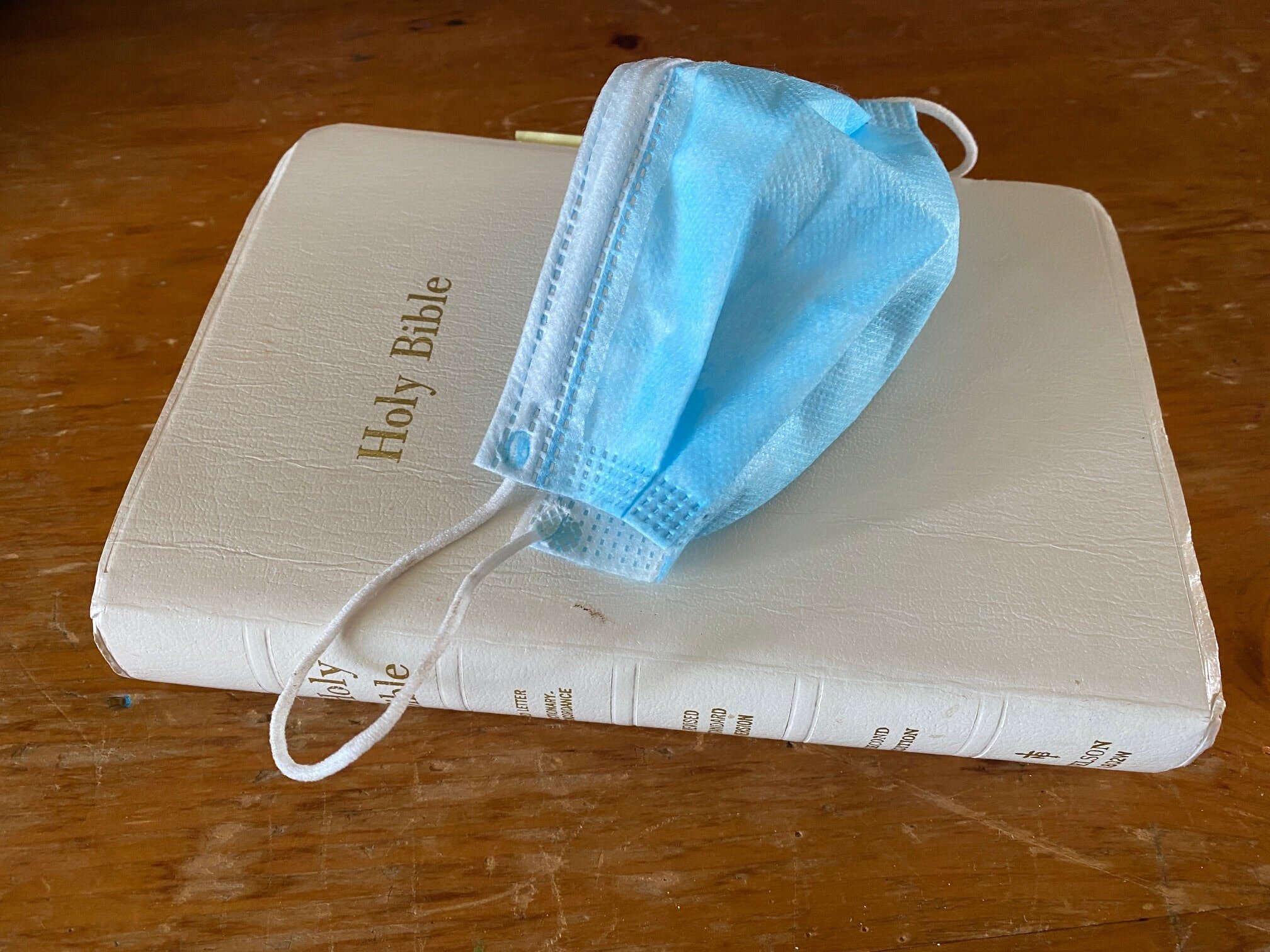 Face mask on a holy Bible