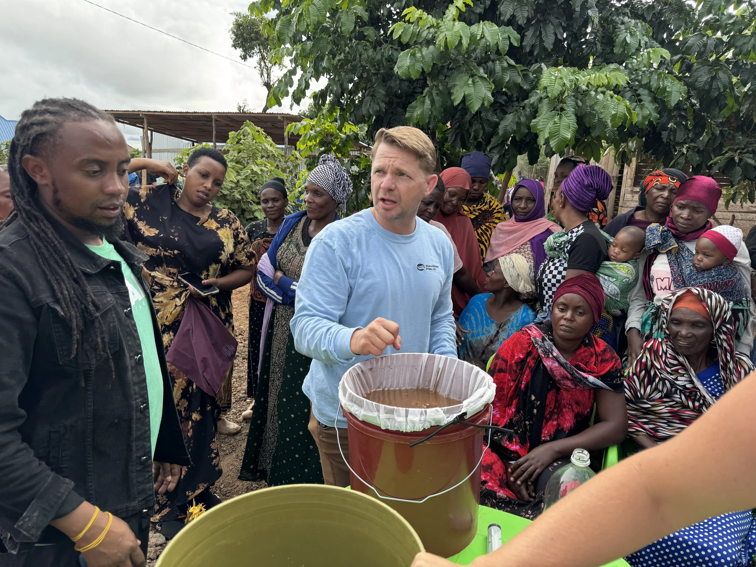 demonstrating how to clean and maintain a water filter in a Tanzanian village