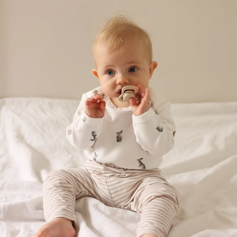 Baby wearing a fledge and thread bunny bodysuit.