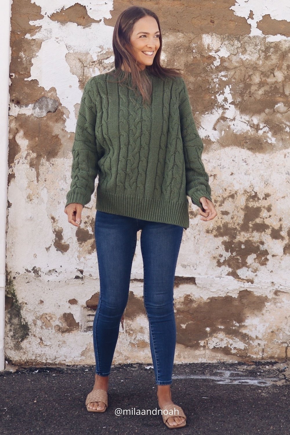 A dark haired girl wearing a thyme green cable knit.