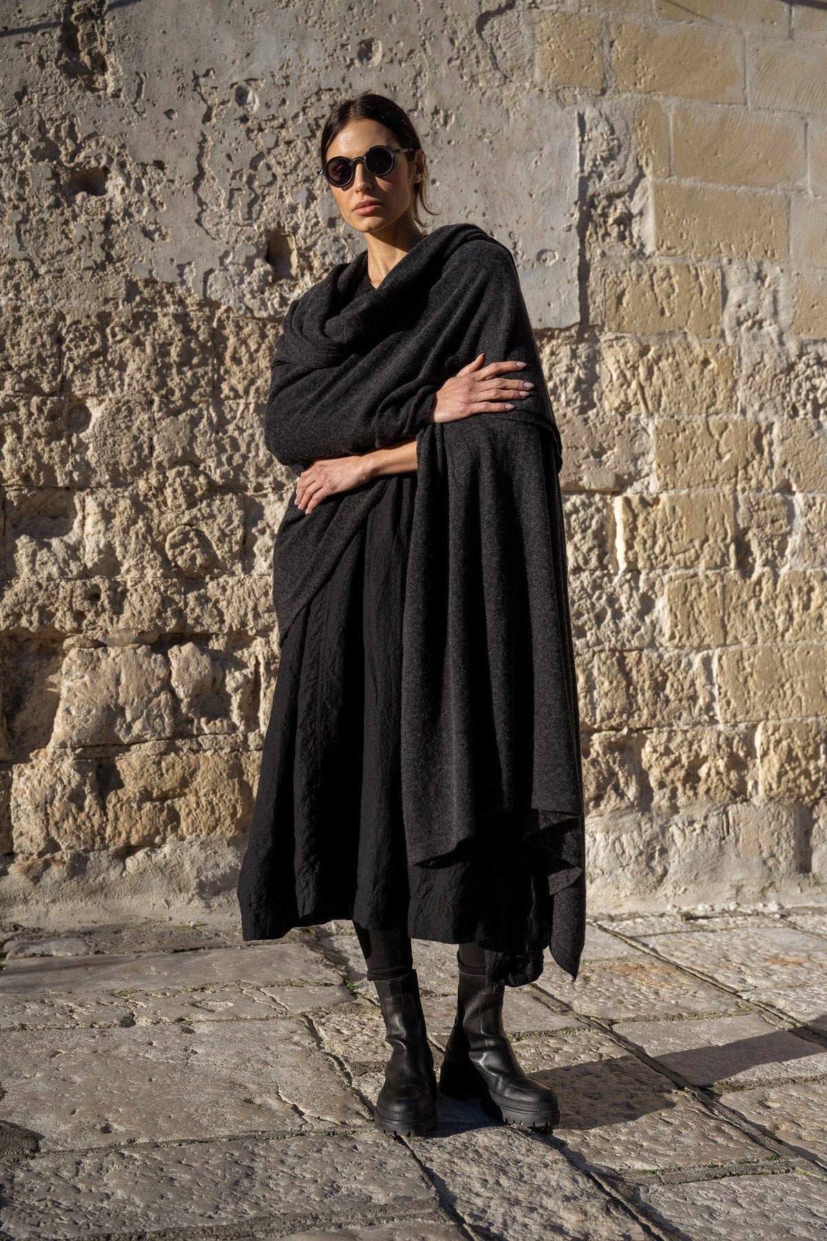 A woman with dark hair wearing a black Meg By Design Winston wool shawl.