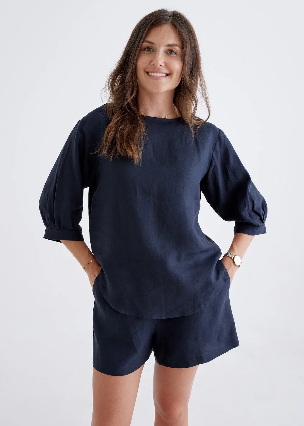 Girl wearing a navy linen shirt with three quarter sleeves.