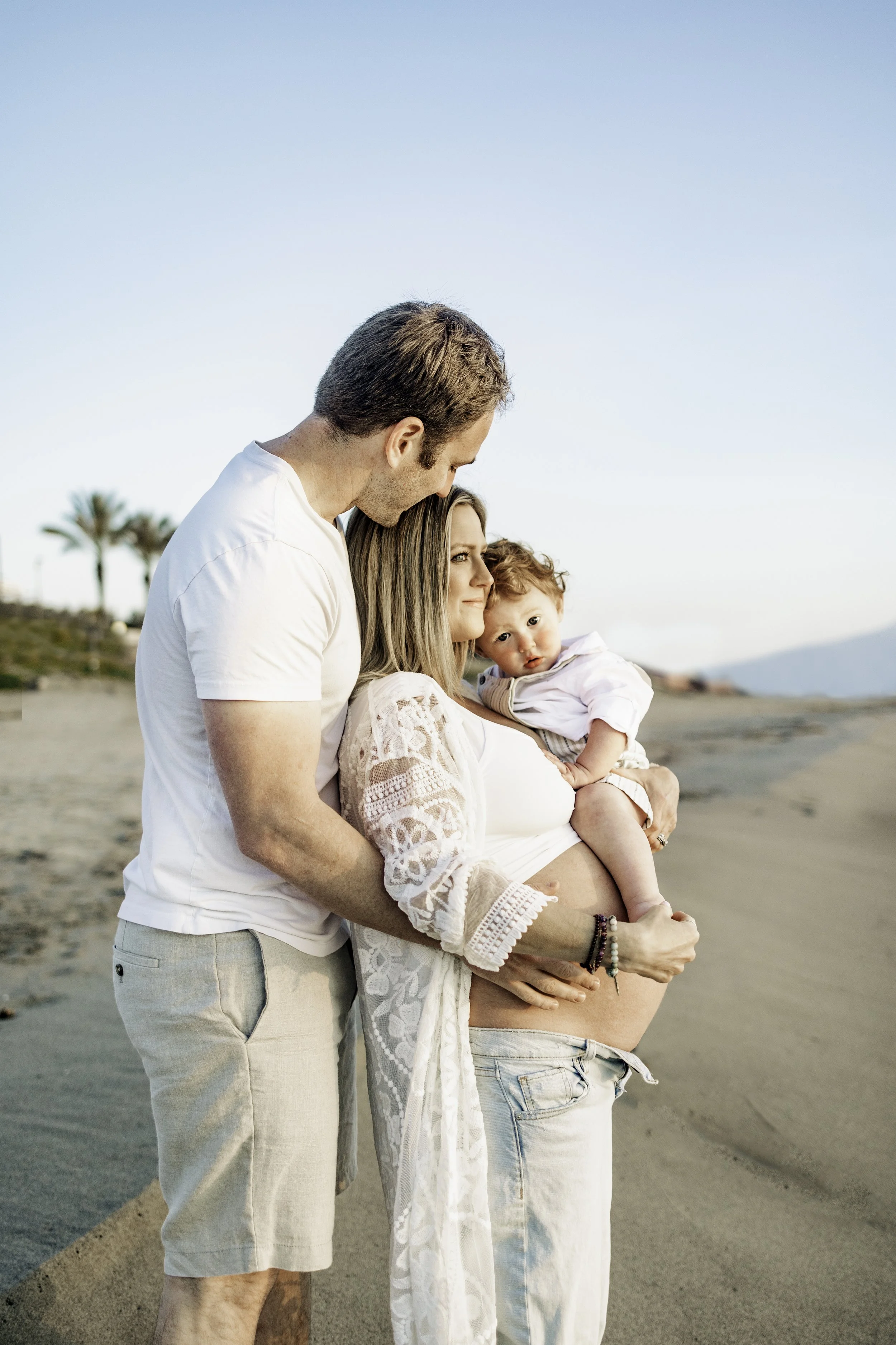 Portrait of a family of three standing on a sandy beach in Sicily
