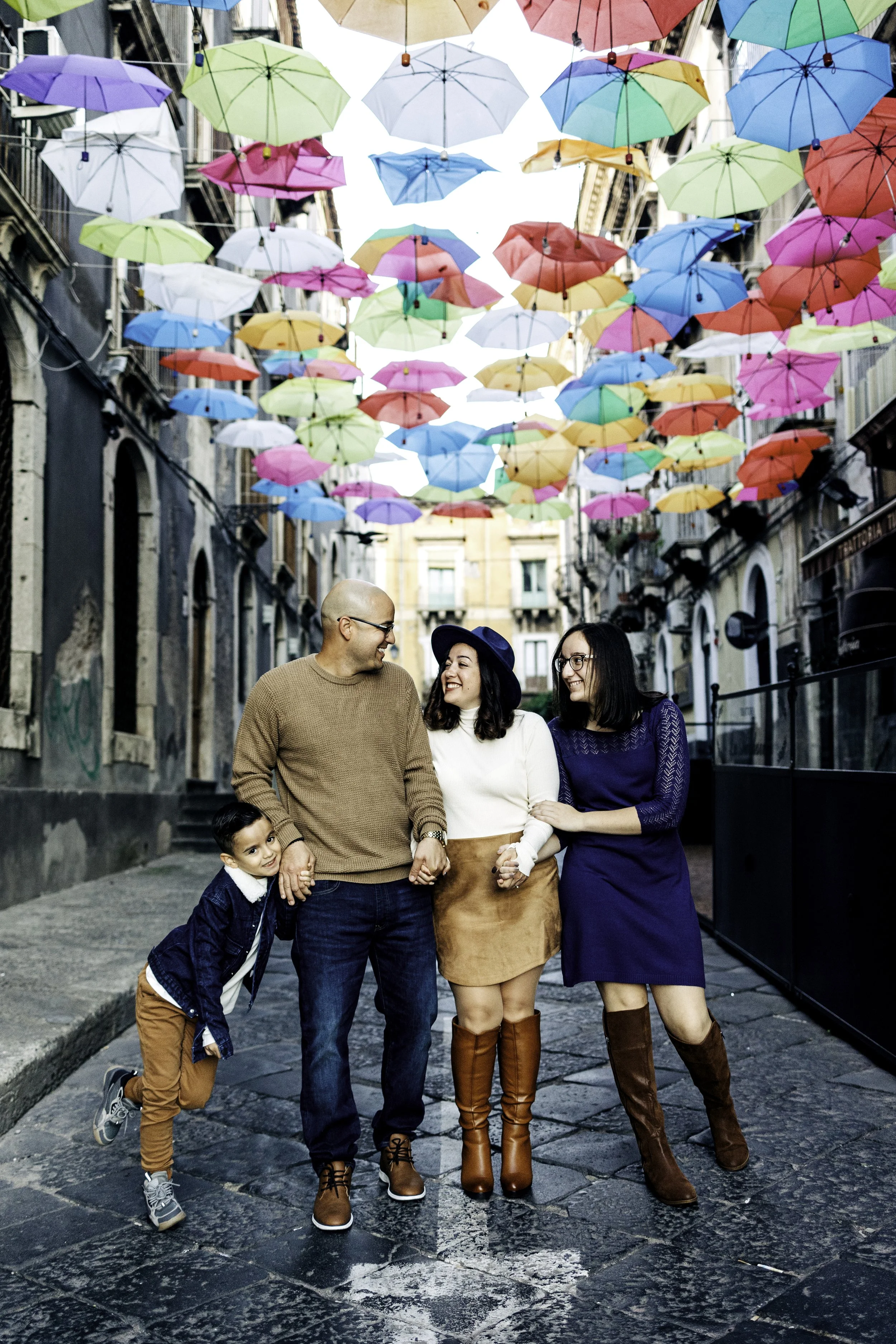 Portrait of a family under colorful umbrellas taken in downtown Catania, Sicily