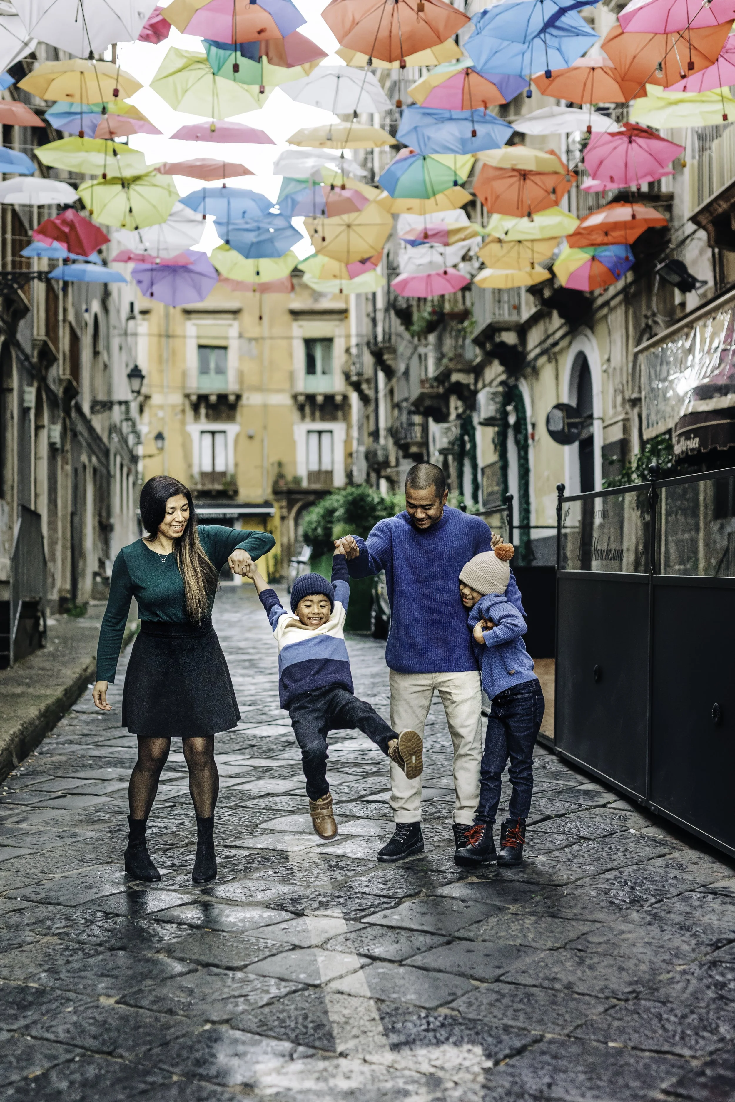 Family photosession under colorful umbrellas in Downtown Catania