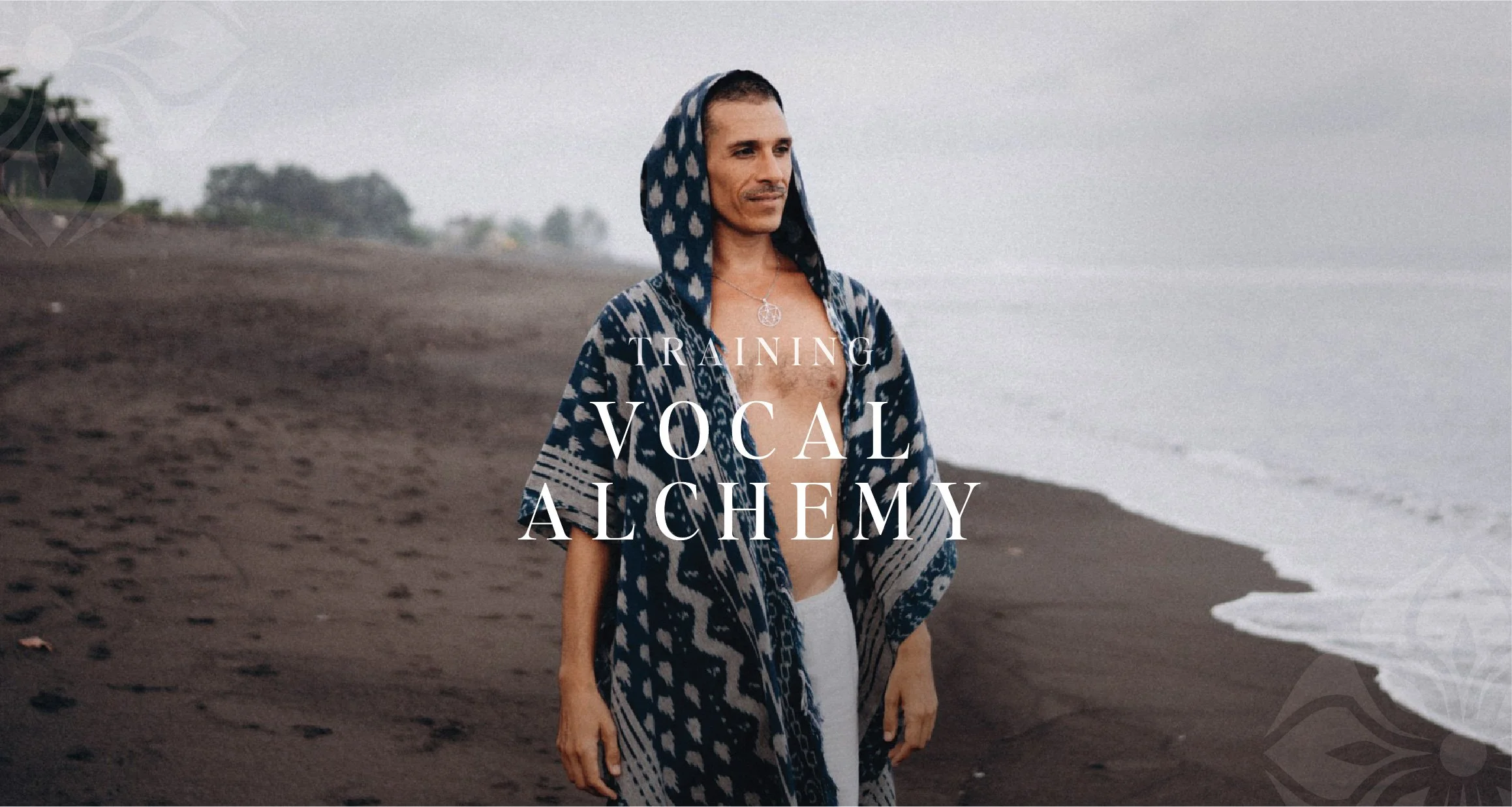 A man wearing a blue patterned hooded shawl stands on a dark sandy beach near the ocean, with trees in the background. The overlay text reads 'Training Vocal Alchemy.'