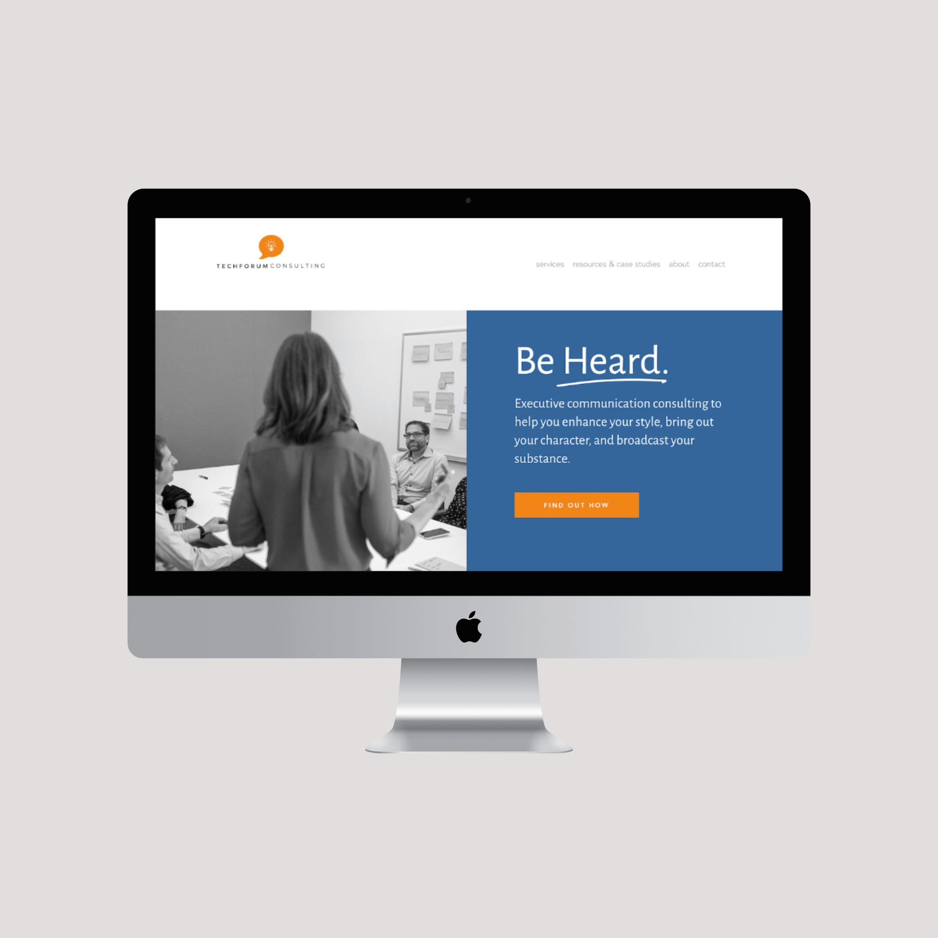 An iMac computer screen displaying a business website for TechForum Consulting, featuring a black-and-white photo of a woman speaking in a meeting with three seated colleagues, and a blue section with white text and an orange button that says 'Find Out How.'