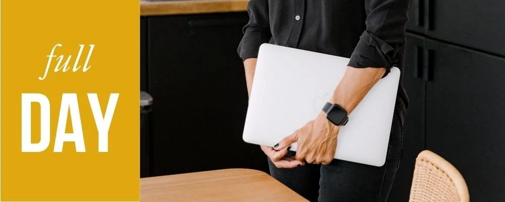 Person holding a closed laptop and wearing a smartwatch, standing next to a wooden table and black cabinet, with a gold banner on the left that says 'full DAY'.