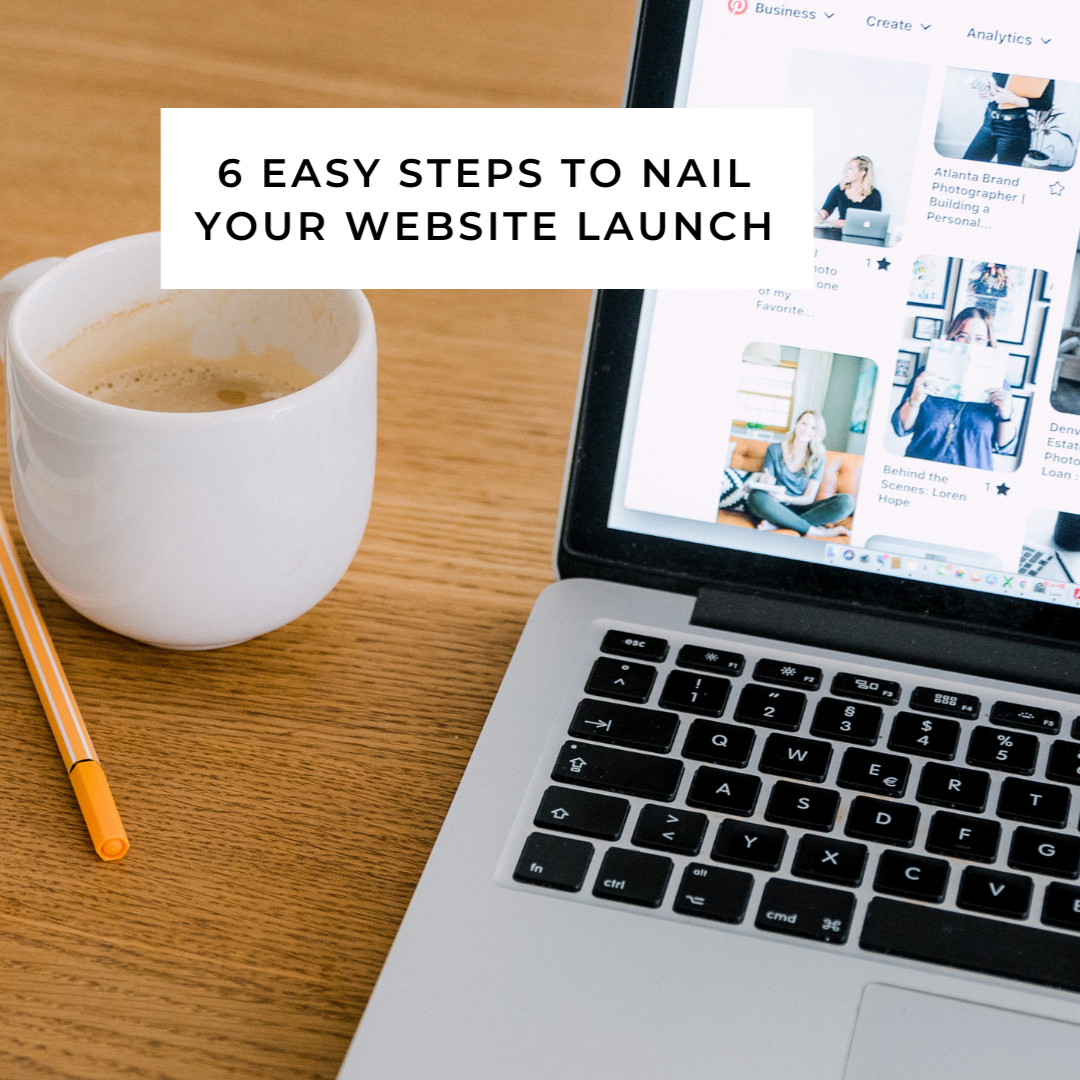 Smiling woman sitting at a desk with a silver MacBook laptop in a home office. Shelf with books and decorative items behind her.