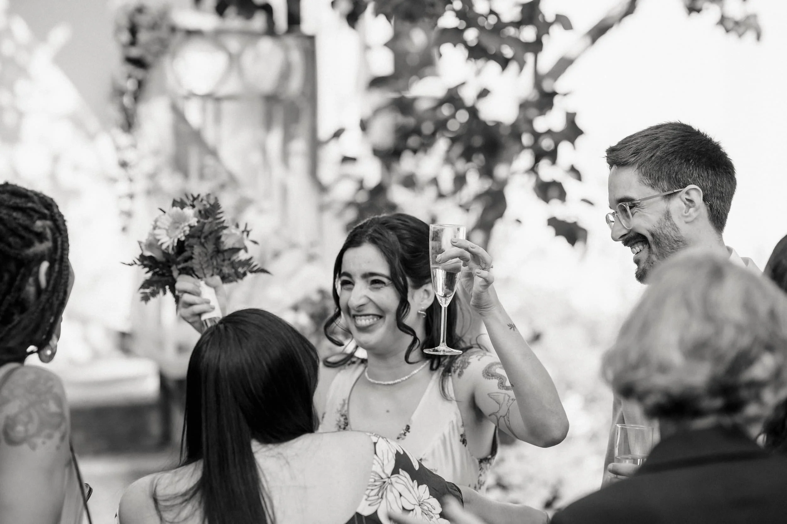 People smiling and holding glasses at a celebration. A smiling couple at a wedding photo shoot in Stockholm