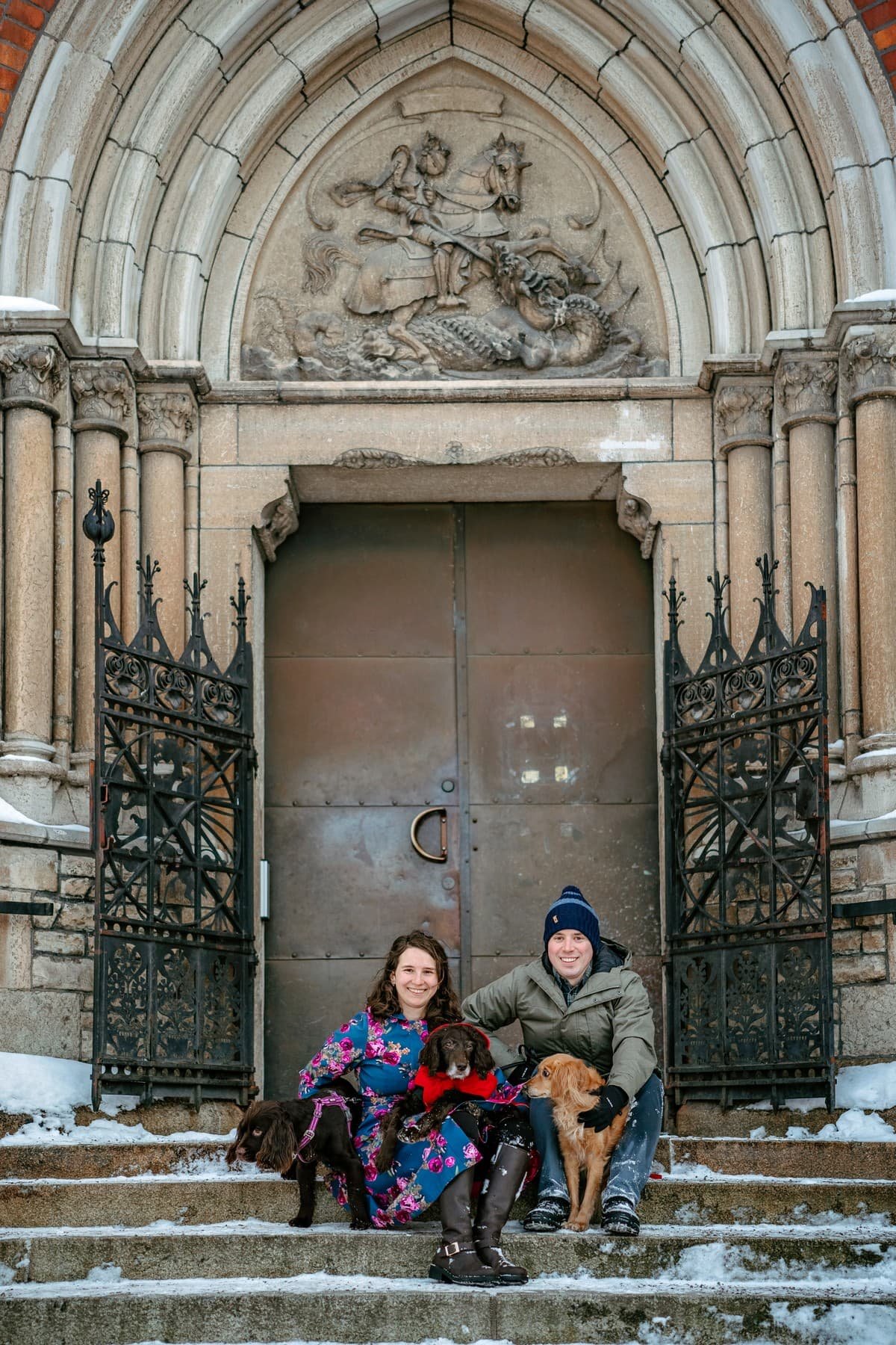 Two people sitting on steps in winter, holding an old dog in end of life photography session in Stockholm
