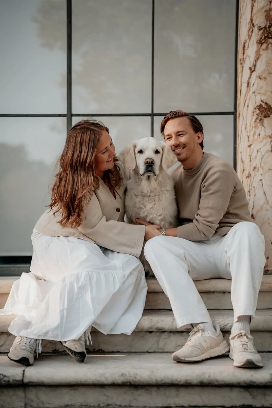 Couple with their dog posing at Haga Parken in Stockholm during a soft afternoon photo shoot.