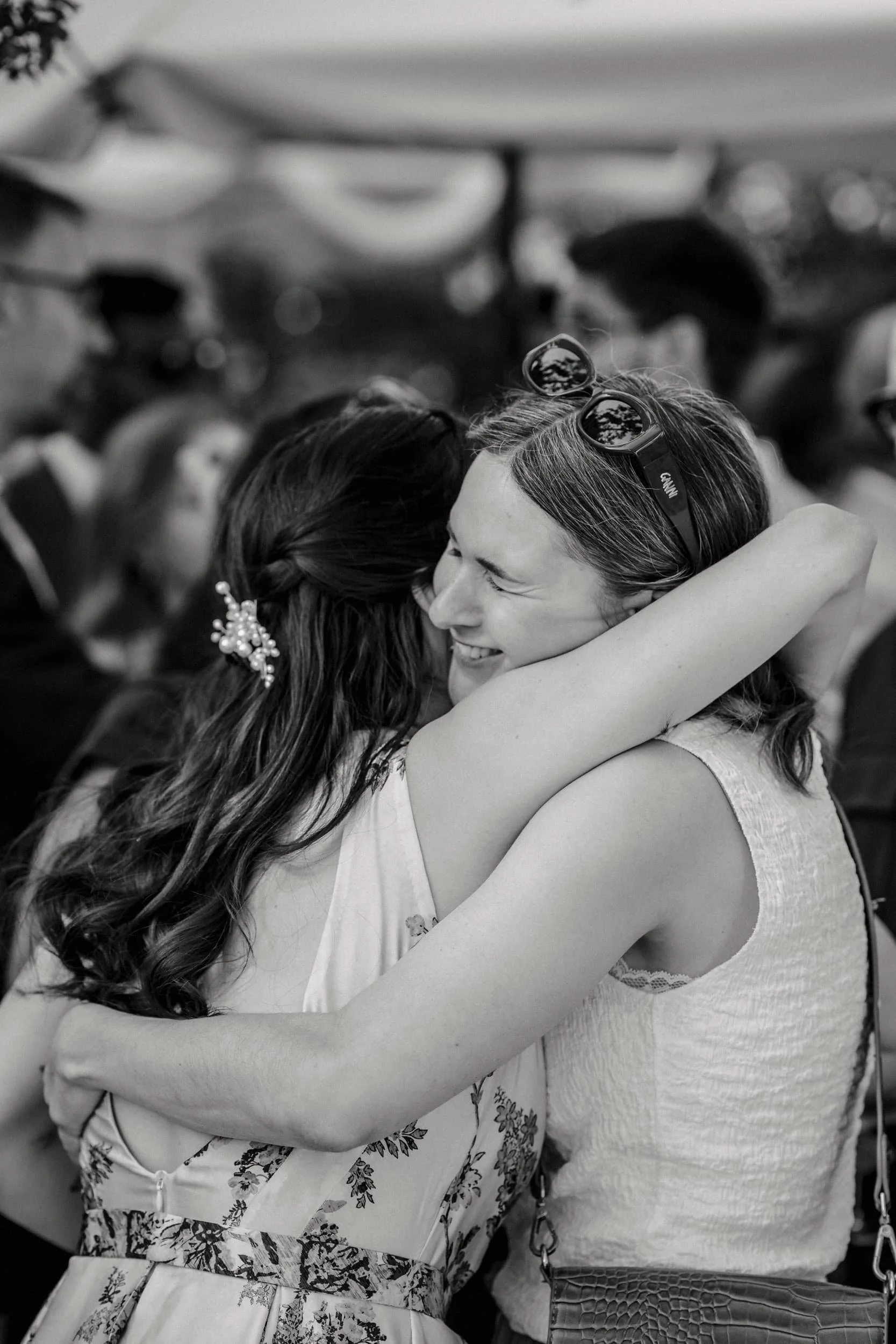 Two women hugging each while a wedding photographer take photos in Stockholm