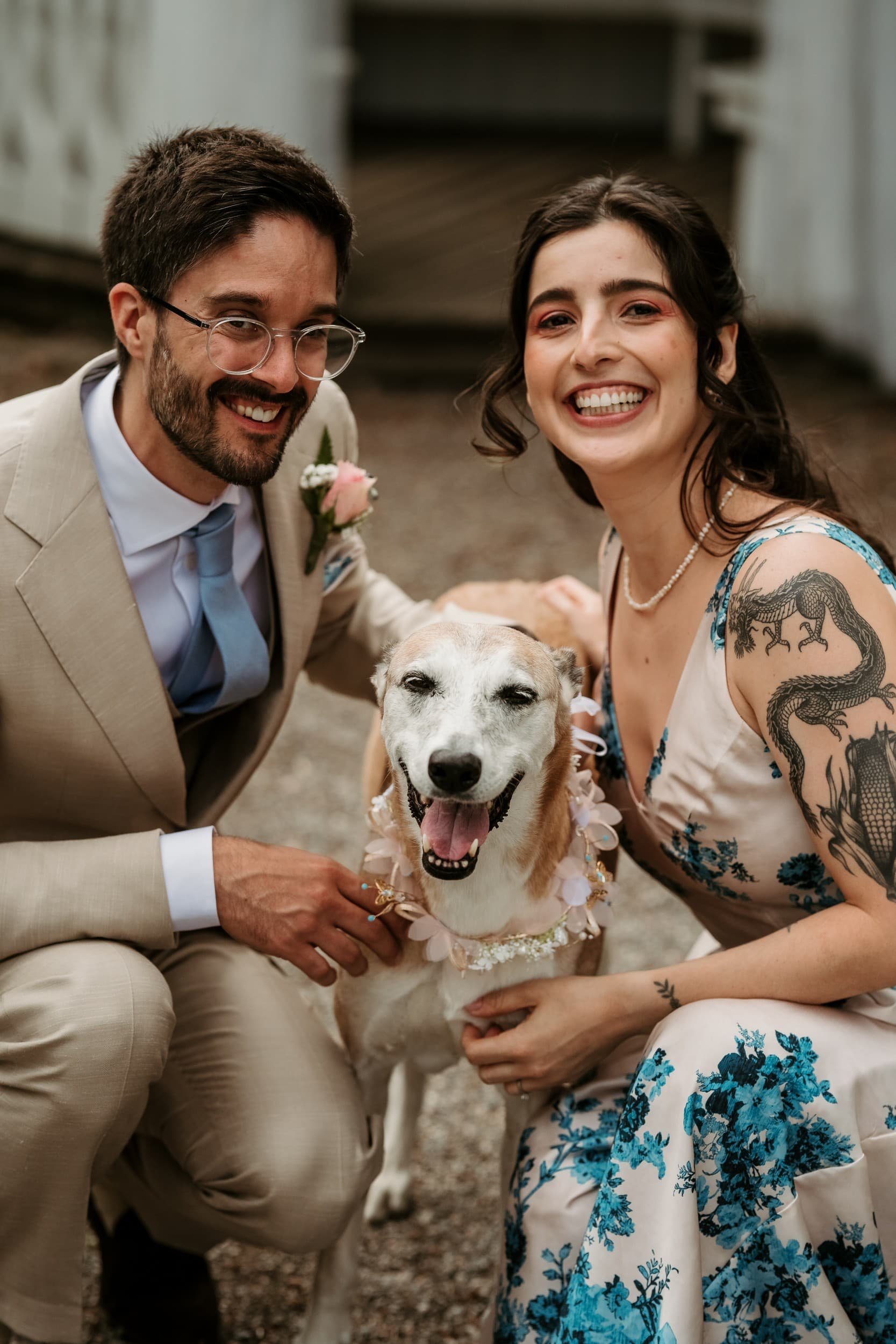 A smiling couple posing with a happy dog at a wedding during wedding photo shoot in Stockholm