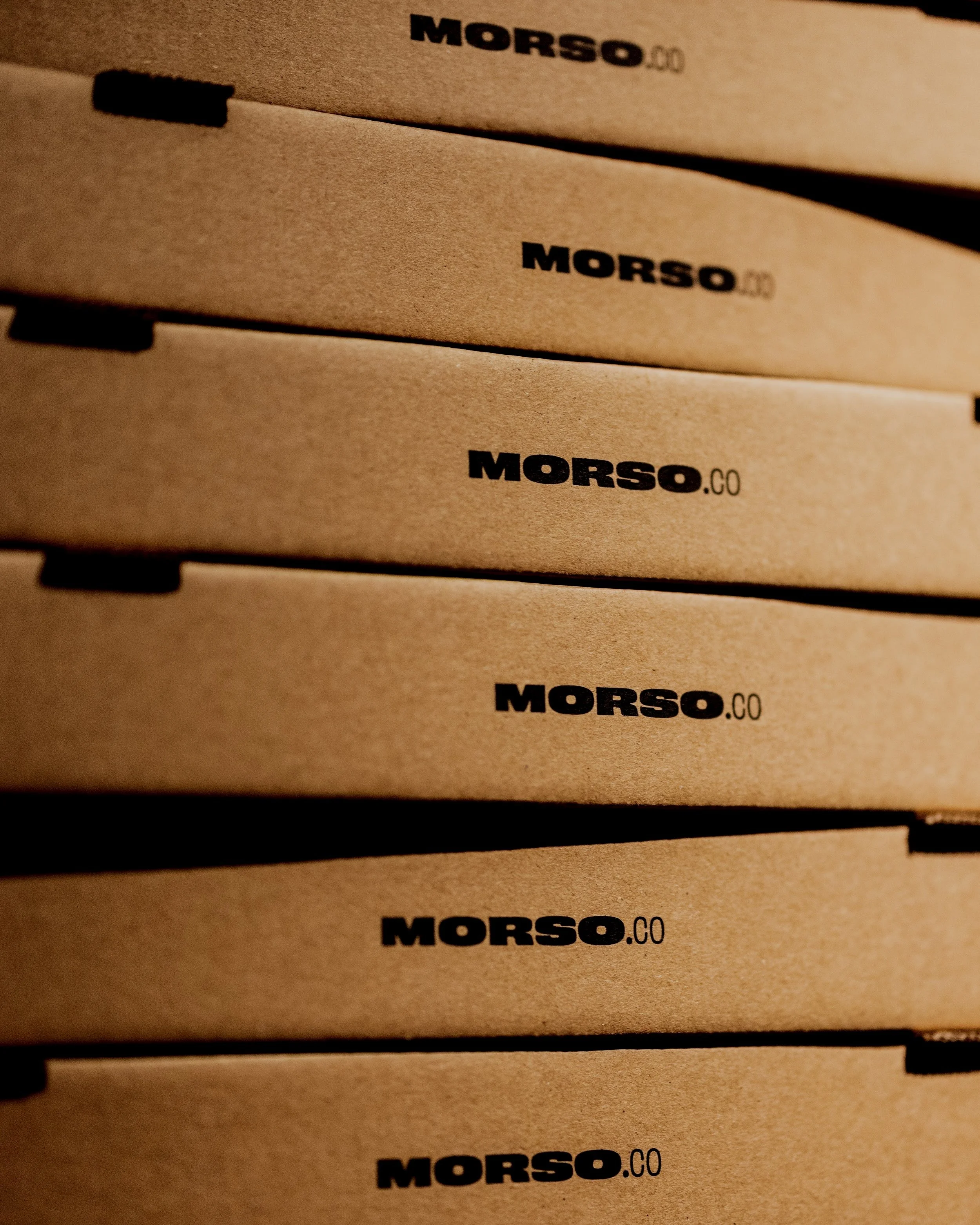 Piles de boîtes en carton avec l'inscription 'MORSO.CO' en noir.