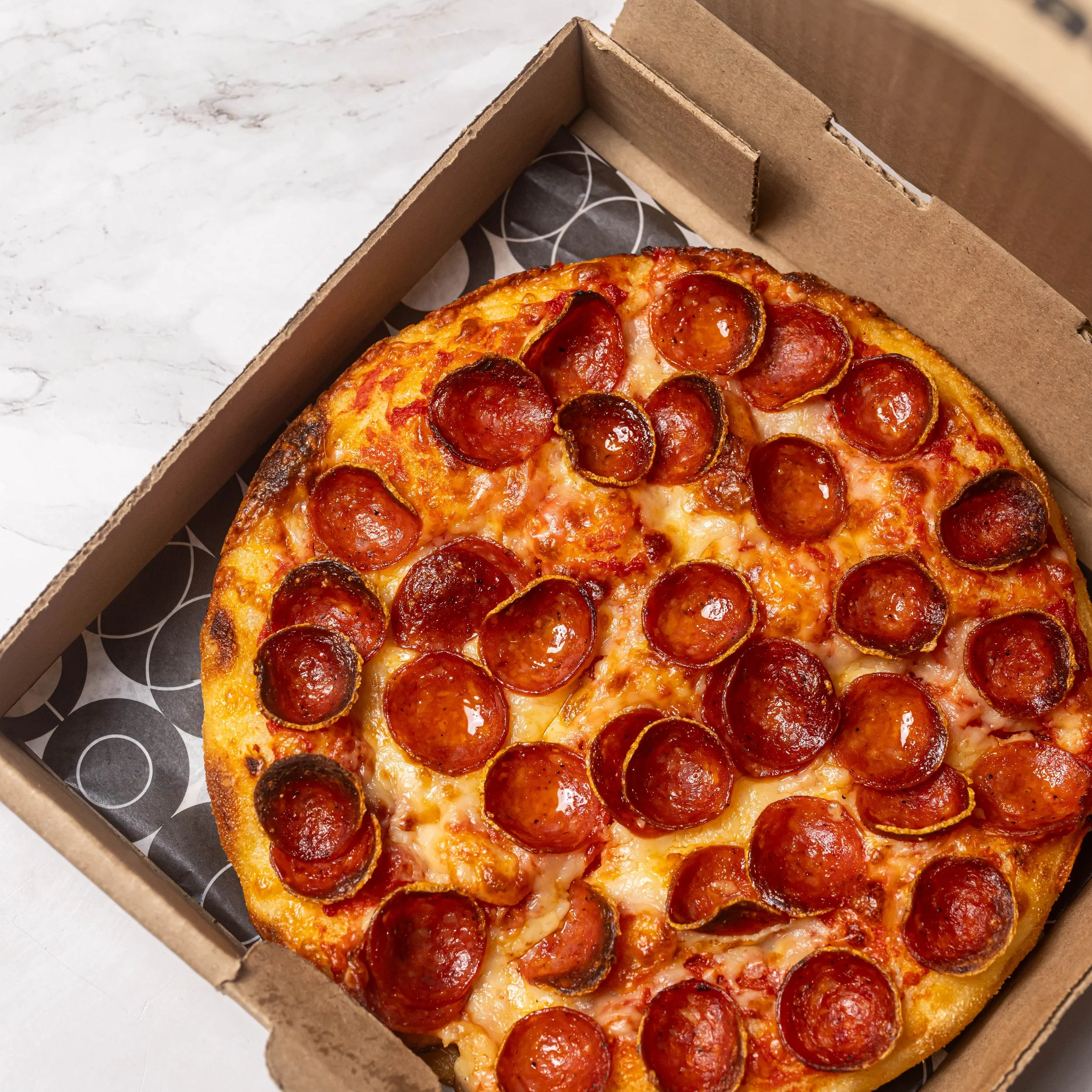 Pizza pepperoni dans une boîte à emporter