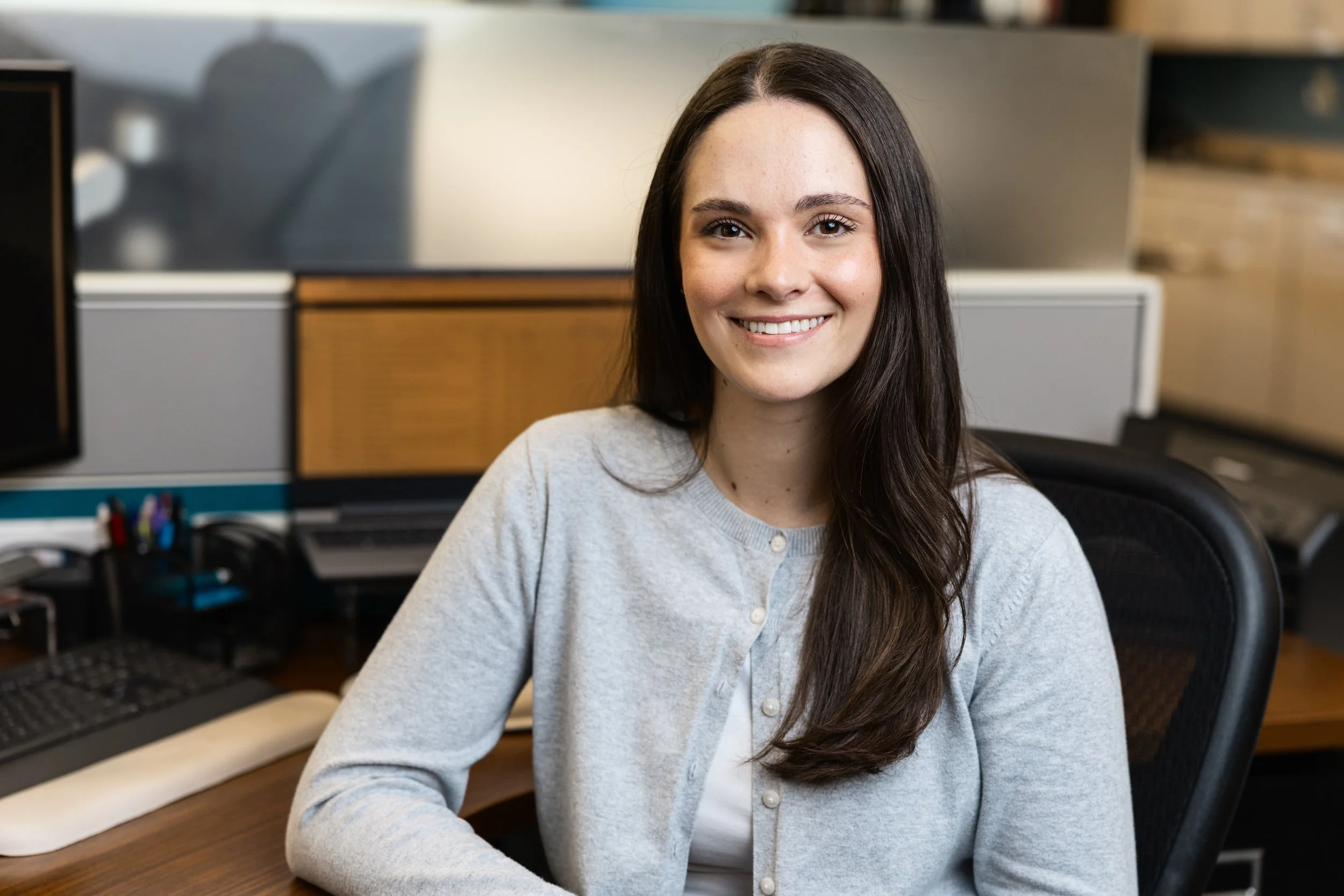 Summer Pearson smiling at camera while sitting in an office environment