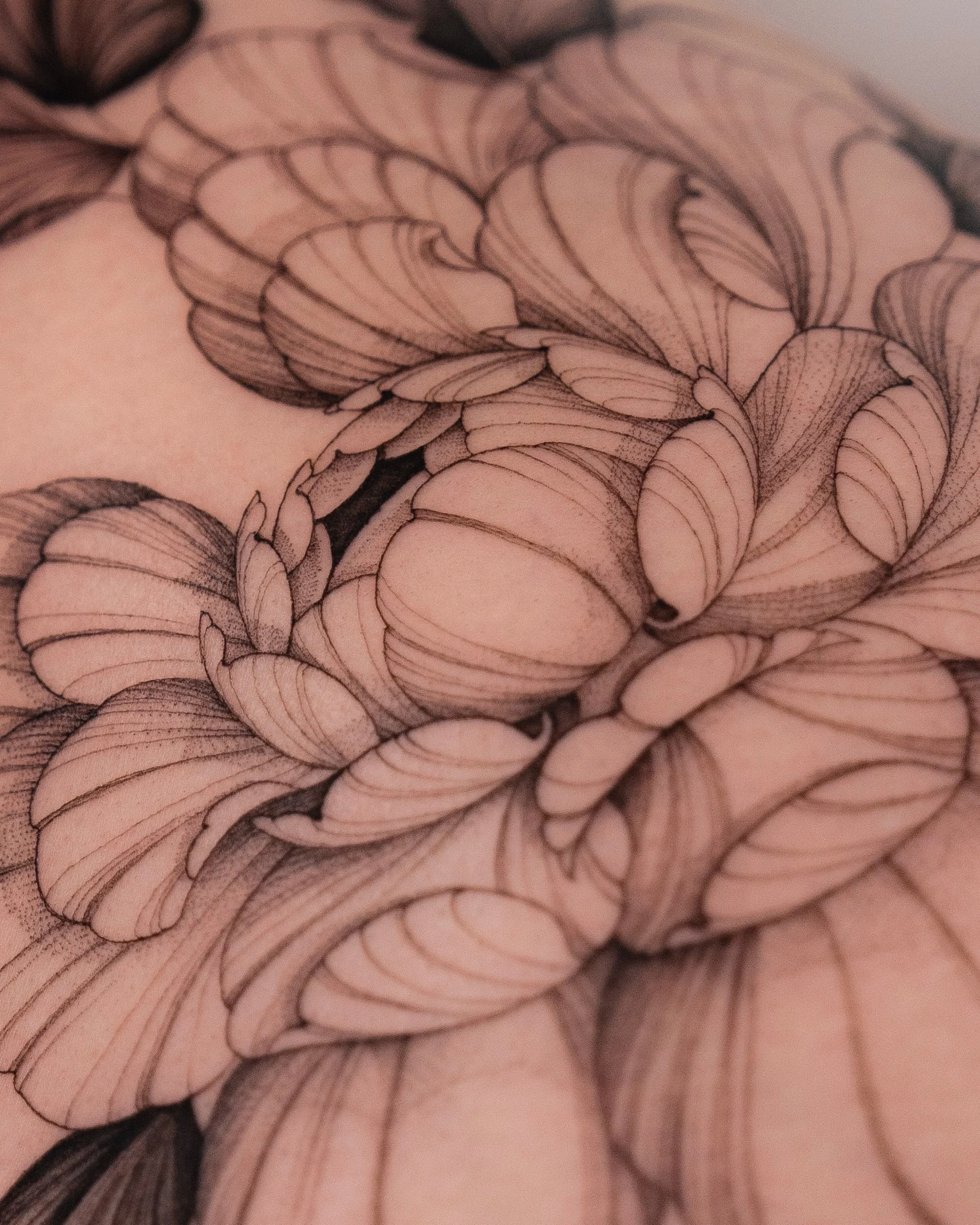 Up close and personal with @madisonbloom.ink.

Rooted in fine-line, floral, and realism tattooing, Madison creates elegant compositions that move naturally with the body. Known for her freehand approach and signature peony work, she blends precision 