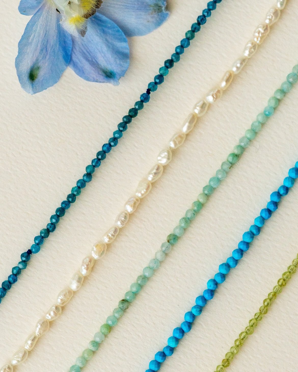 The @anthi.jewelry Petra Chain is now available in Apatite and Pearl, joining Peridot, Aquamarine and Turquoise to perfect your layers this summer ✨

Why I designed it&hellip;I love adding a splash of color to my necklace stories. Finished with handm