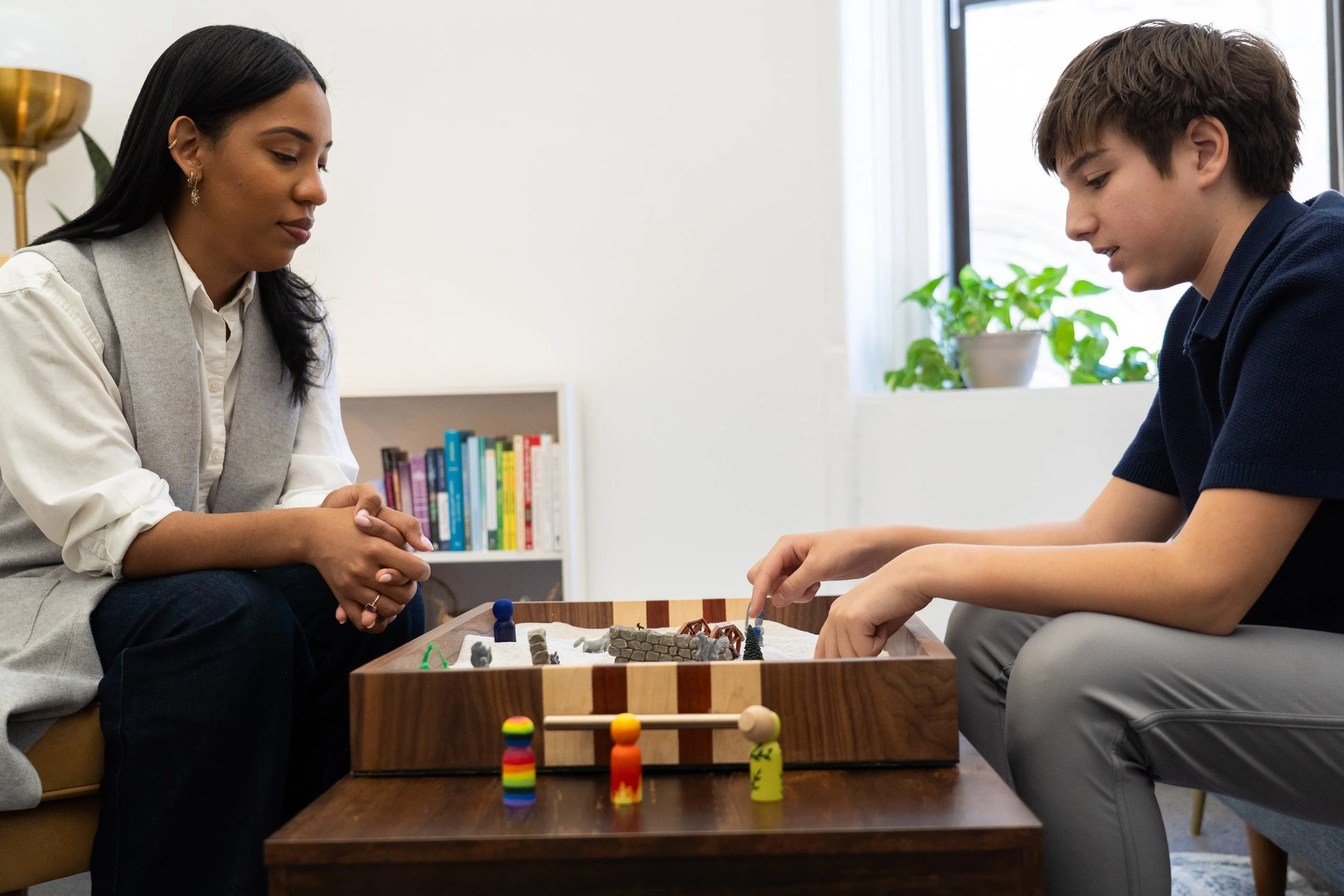 Teen participating in sand tray therapy with a Christian counselor during a counseling session in New York City, offering faith-integrated mental health support for adolescents.