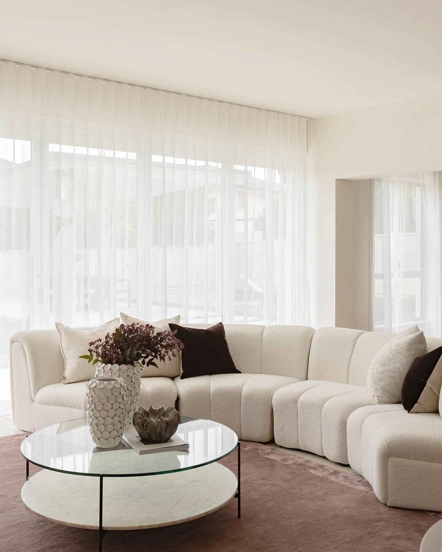 A room filled with plenty of natural light, our team took the opportunity to bring in some bold colour with this stunning grape rug. 
Paired with a soft beige sofa, it provided the perfect contrast. From there, we&rsquo;ve opted for a round coffee ta