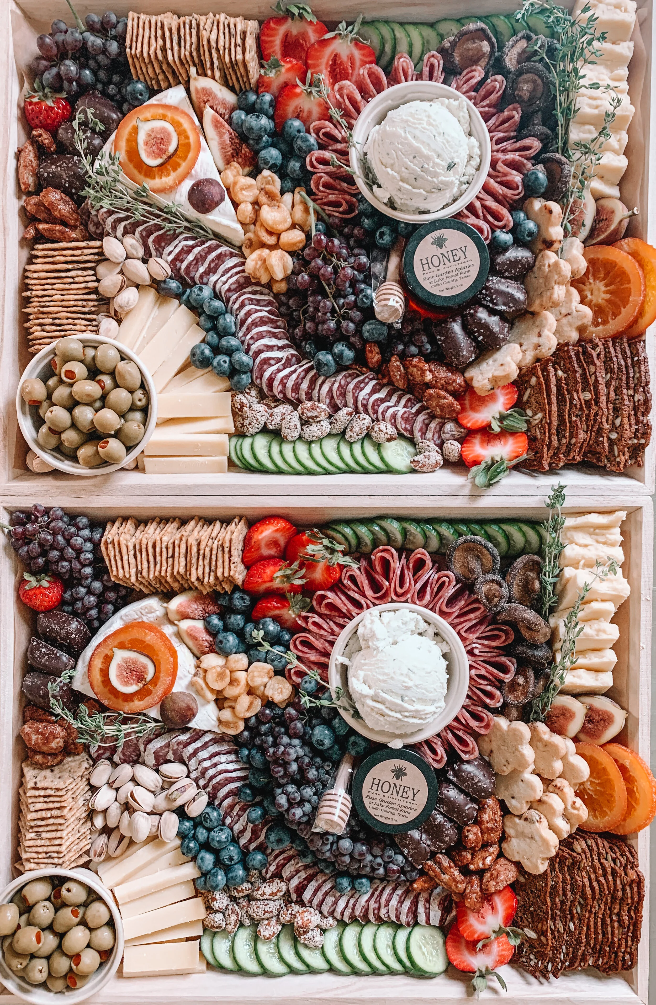 Charcuterie board with cheese, meats, fruits, nuts, crackers, and honey.