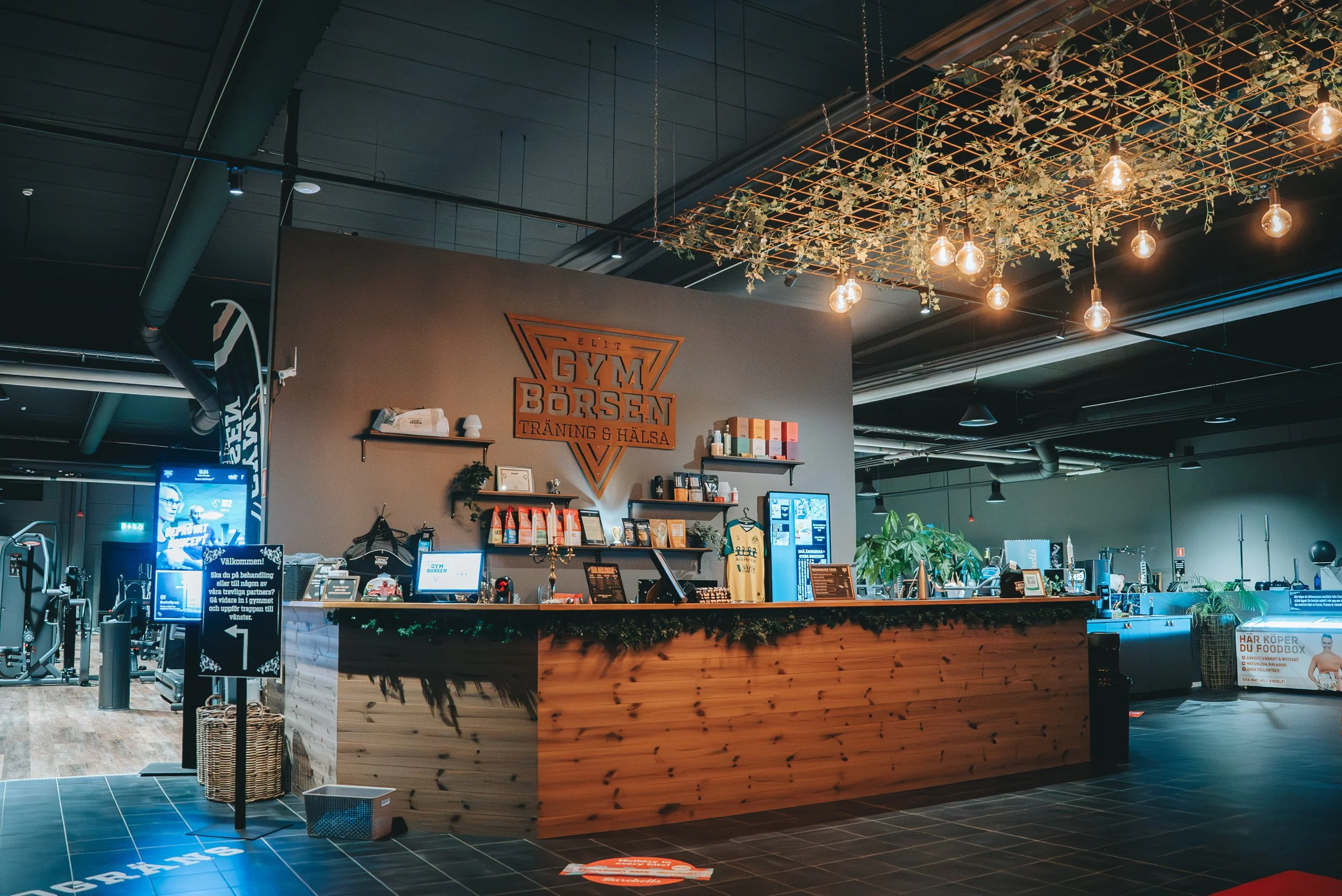 Inbjudande reception till gymmet med logo och kosttillskott som vassle & kreatin