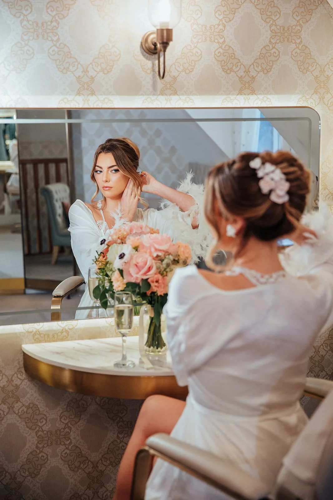 Cherry Blossom and Trillium bridal hairpiece in pale pink and white with pearl accents, styled on a sleek updo for weddings.