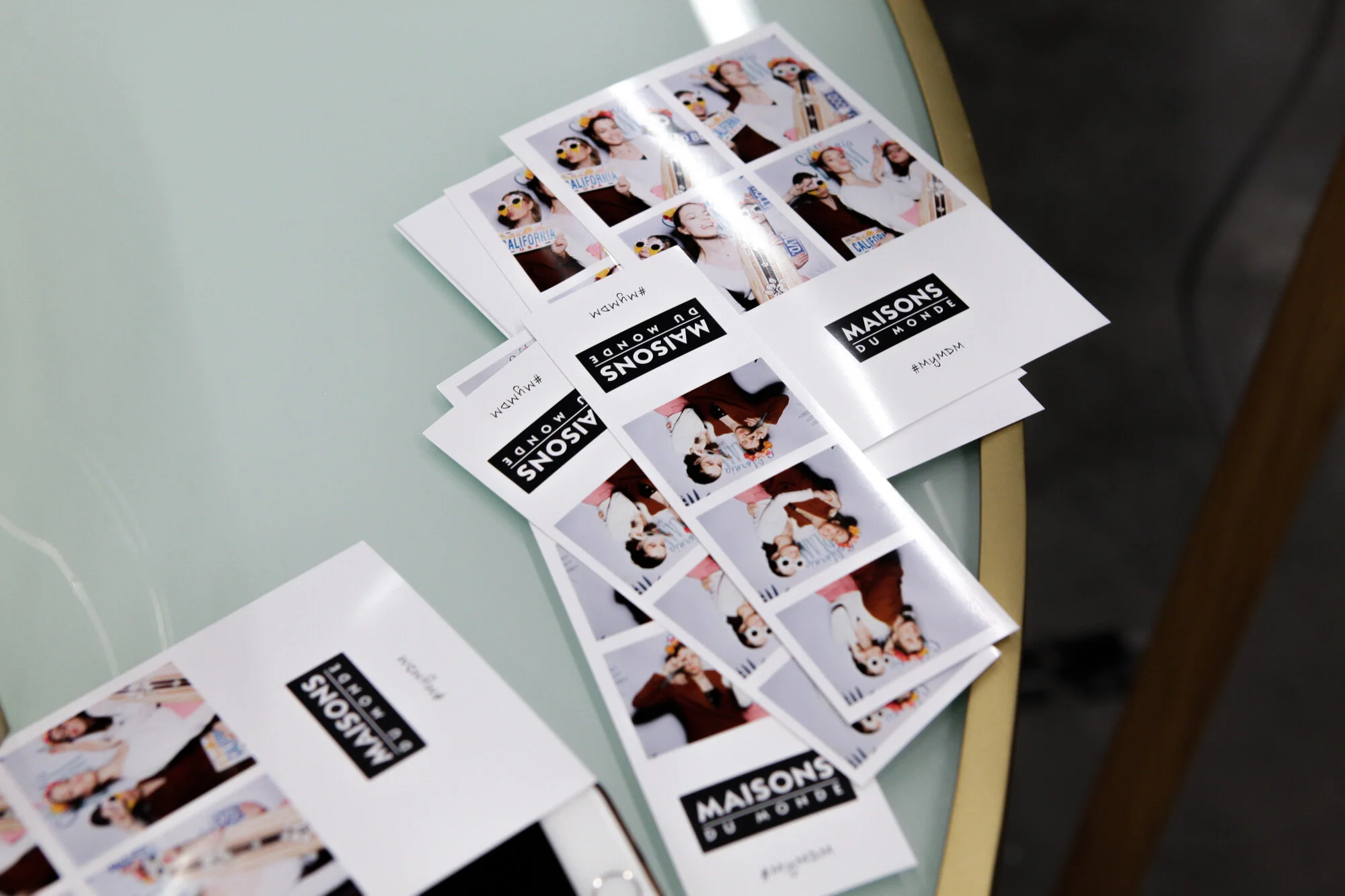 Série de photocalls avec des photos de personnes et des logos de 'MAISONS DU MONDE', disposés sur une table.