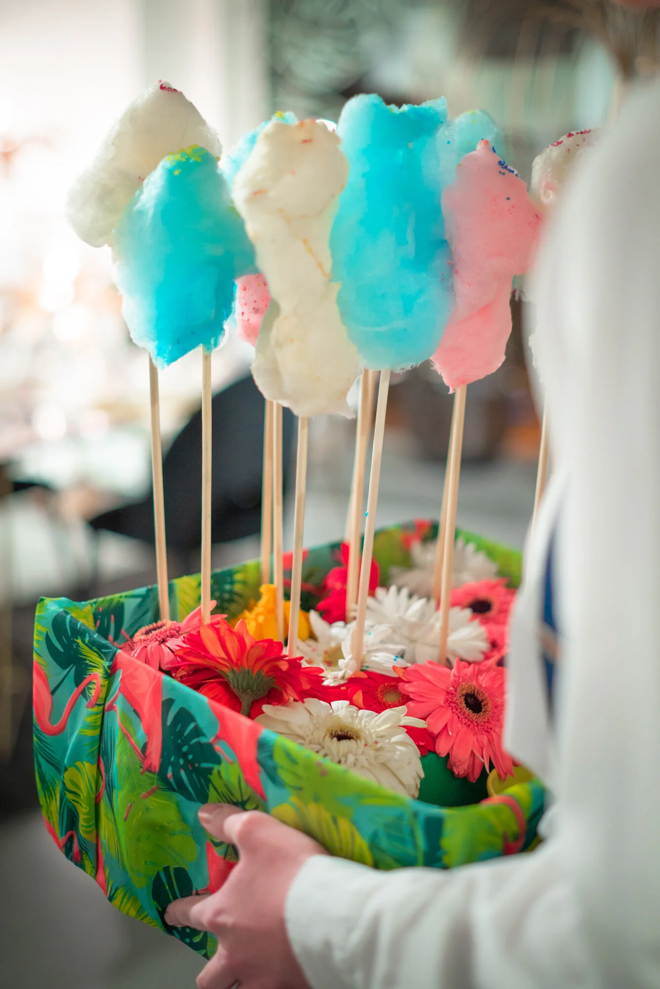 Un panier coloré avec des fleurs et des sucettes en coton de différentes couleurs