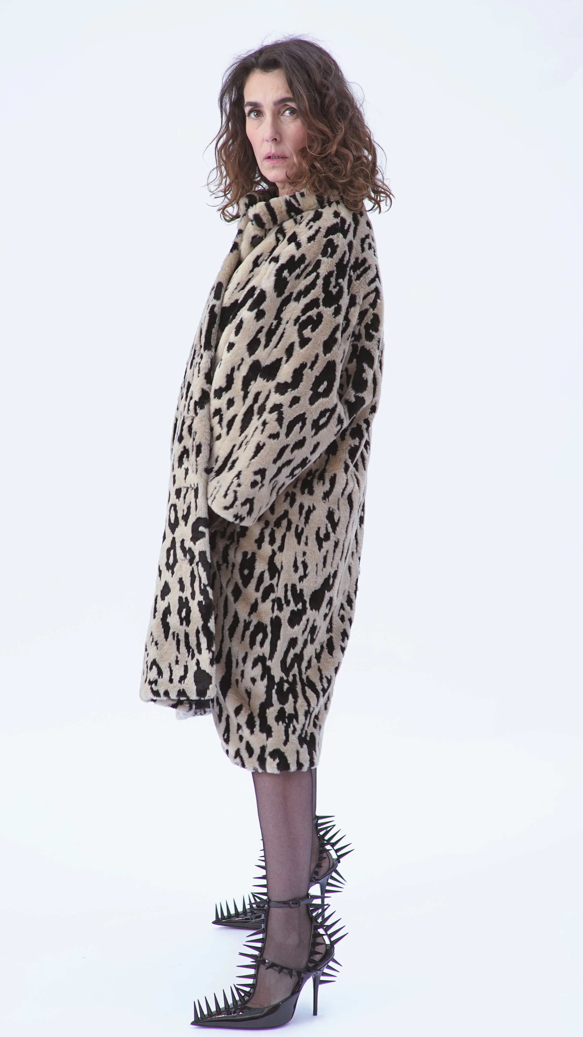 Femme portant un manteau à imprimé léopard, chaussures à talons haut et chaussures à épines