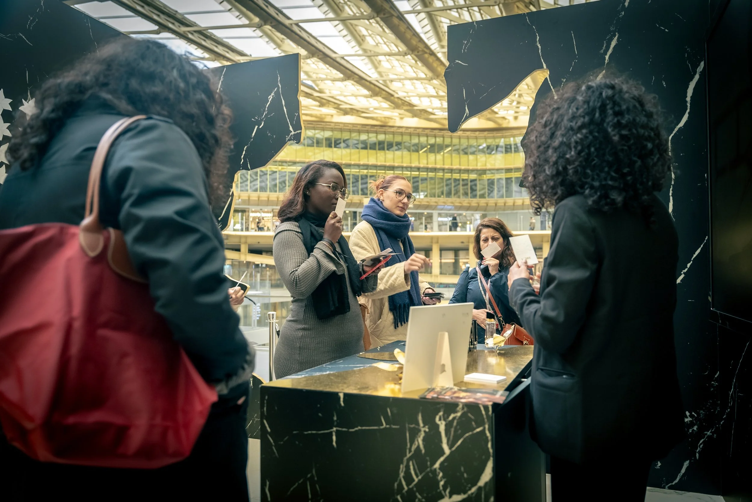 Groupe de femmes faisant la queue au comptoir dans un centre commercial moderniste.