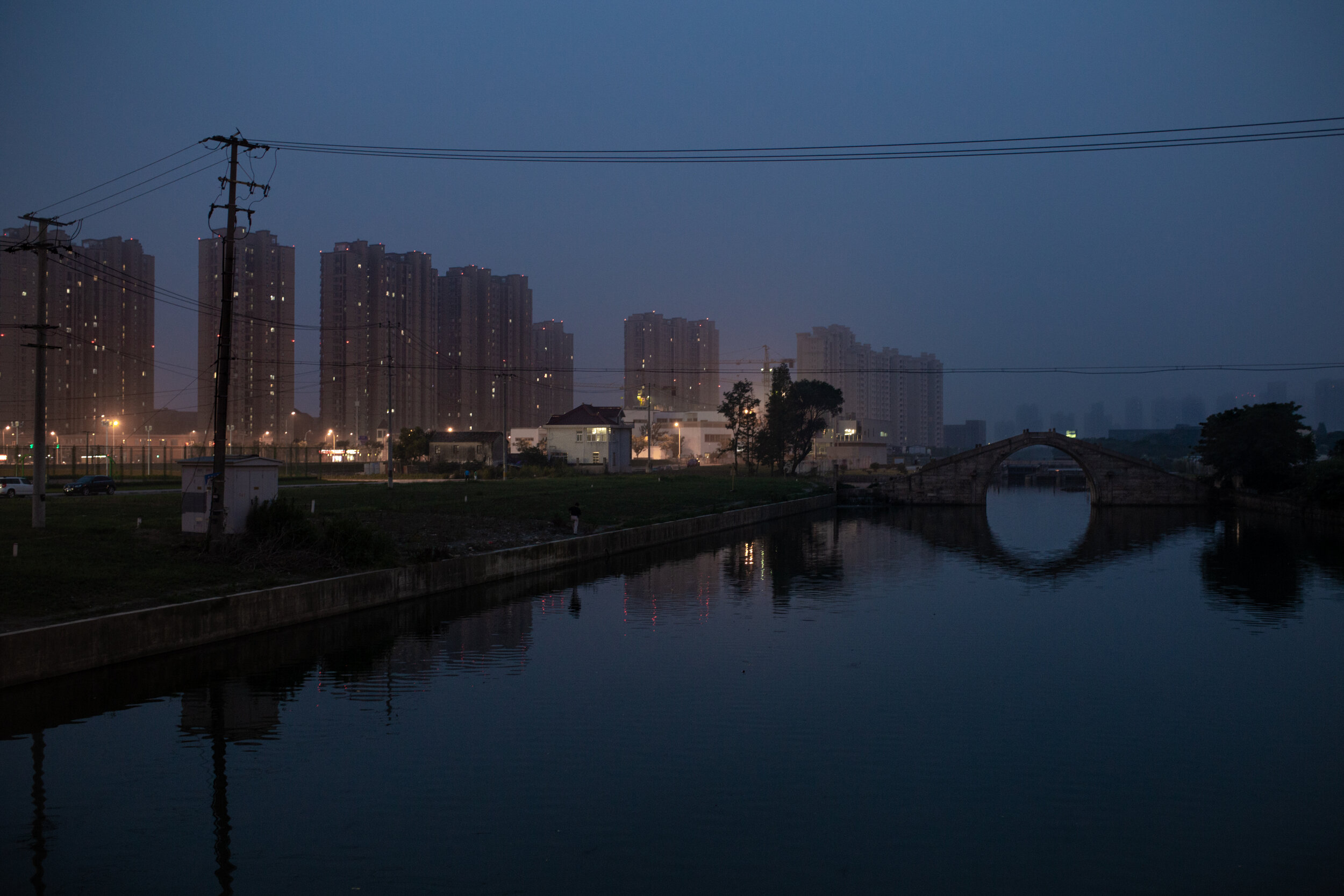  A man goes for an evening stroll in a suburb of Shanghai.  Life in China’s megacities can be very lonely. The apartments are small and the cities massive. Everything is mediated by a cellphone screen. Talking to your friends, ordering food or paying