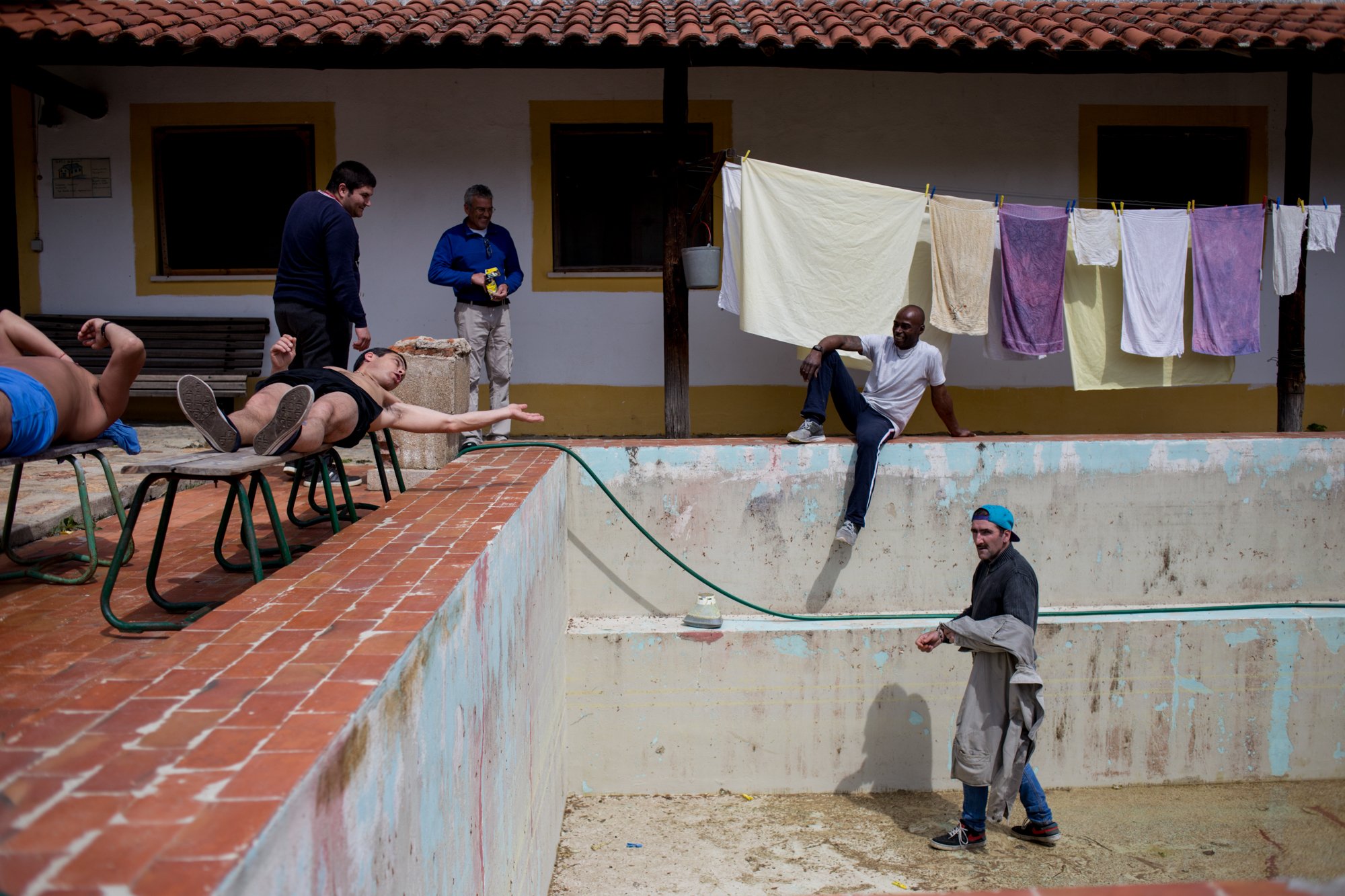  Carlos* (right), step on to the swimming pool, which is being renovated, whilst other patients at Ares do Pinhal Therapeutic Comunity look on.  *name changed 30/03/2017 