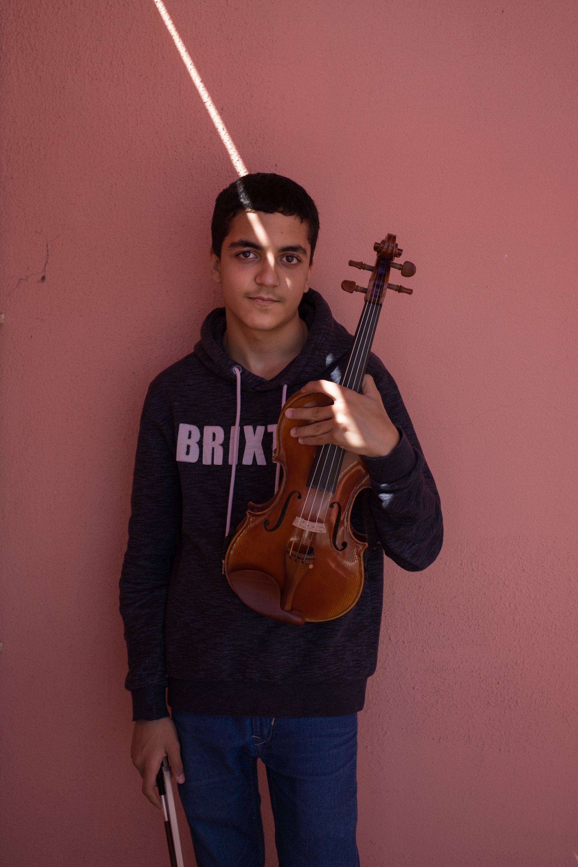  Ali Sina Houtak, 15, poses for a portrait with his violin at the former military Hospital of Ajuda, Lisbon, Portugal. April 2022 