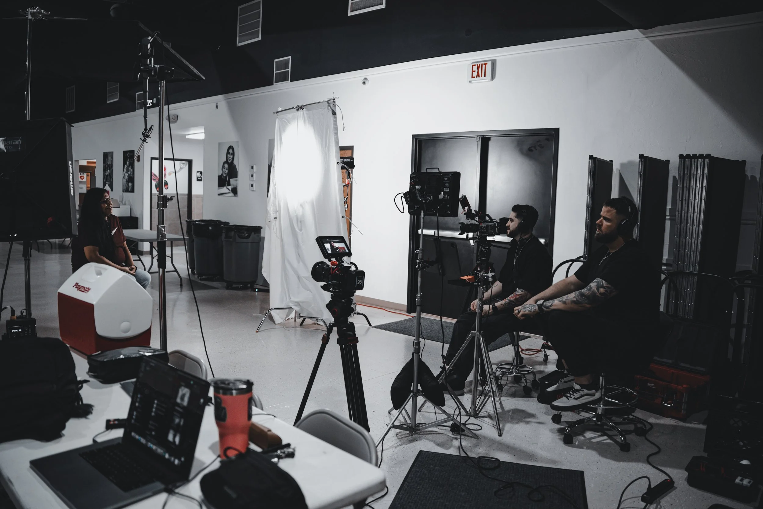 Oklahoma City video production crew filming a client interview in a professional studio with cameras, lighting, and backdrop — Hyped Visuals
